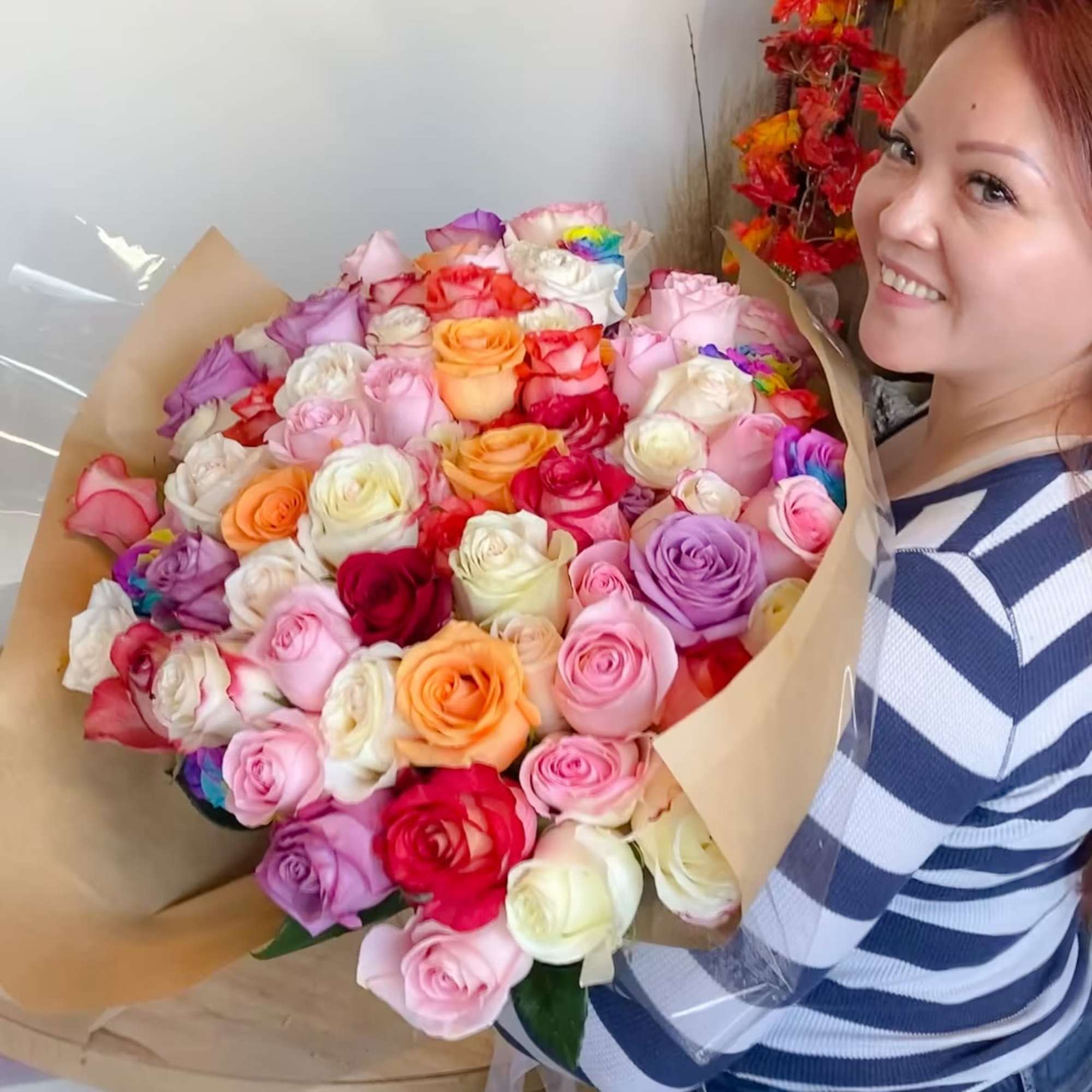 Large bouquet of multicolored roses wrapped in kraft paper