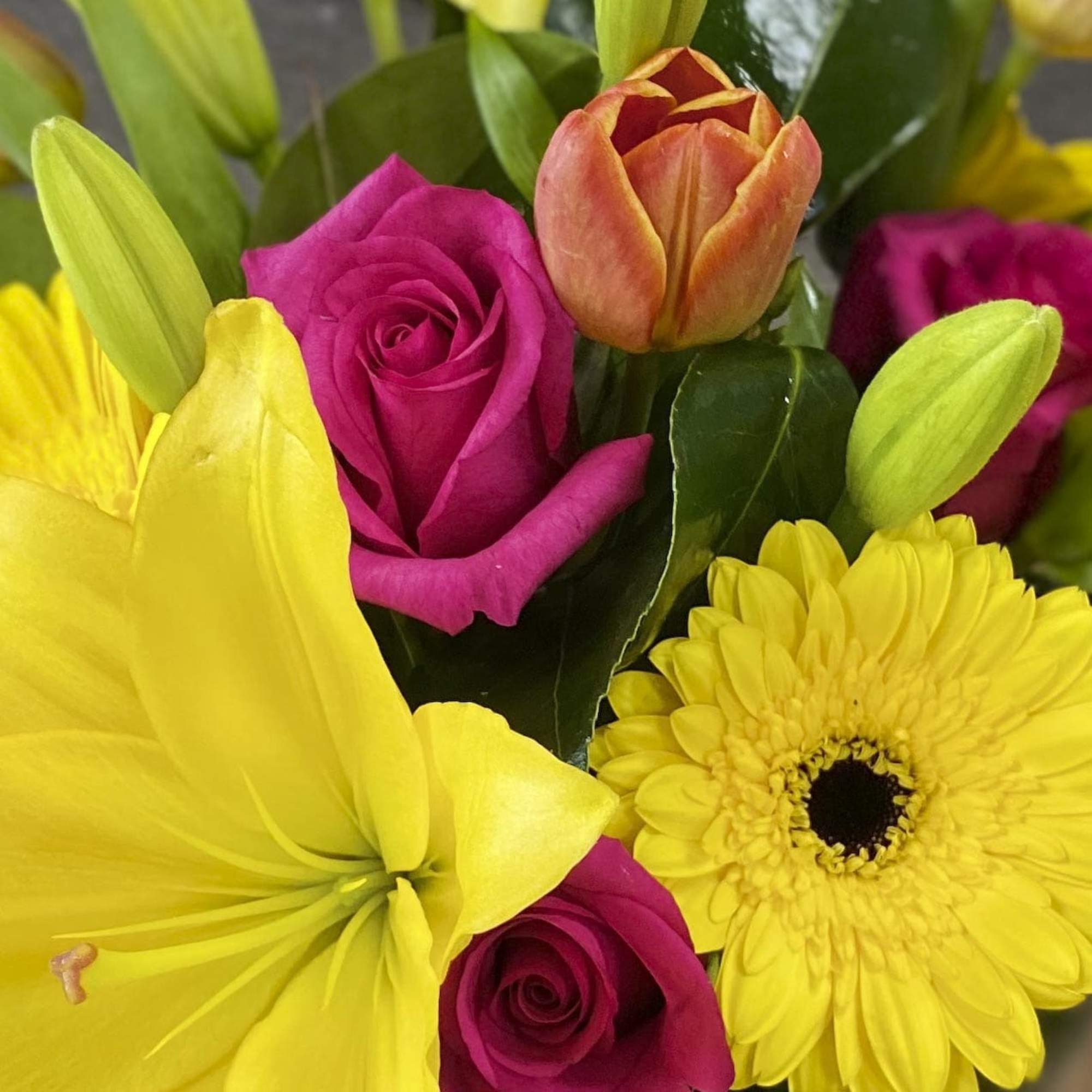 Bright bouquet with yellow lilies, pink roses, and yellow daisies