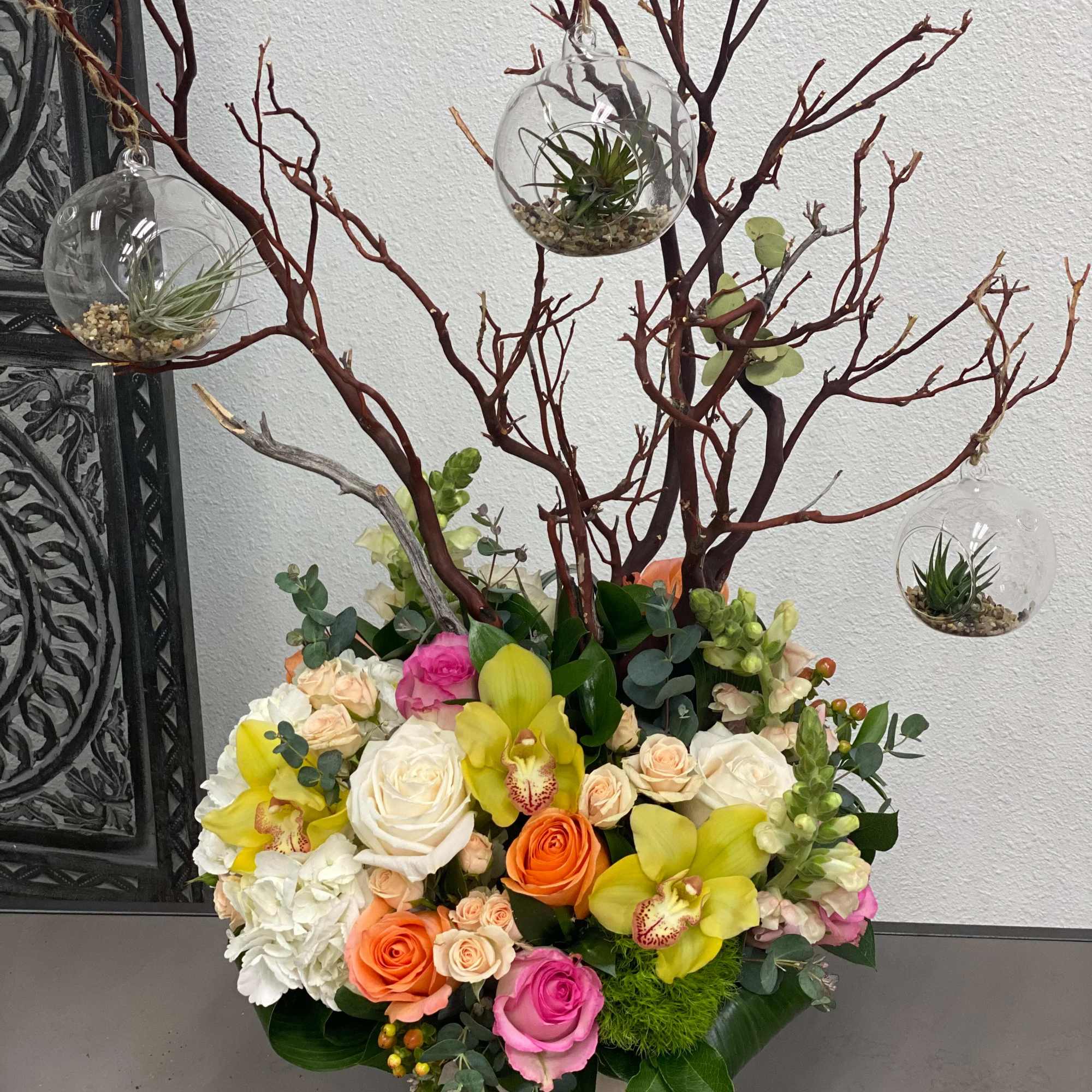 This arrangement includes a vibrant variety of flowers and a manzanita branch, photo 2 of 3