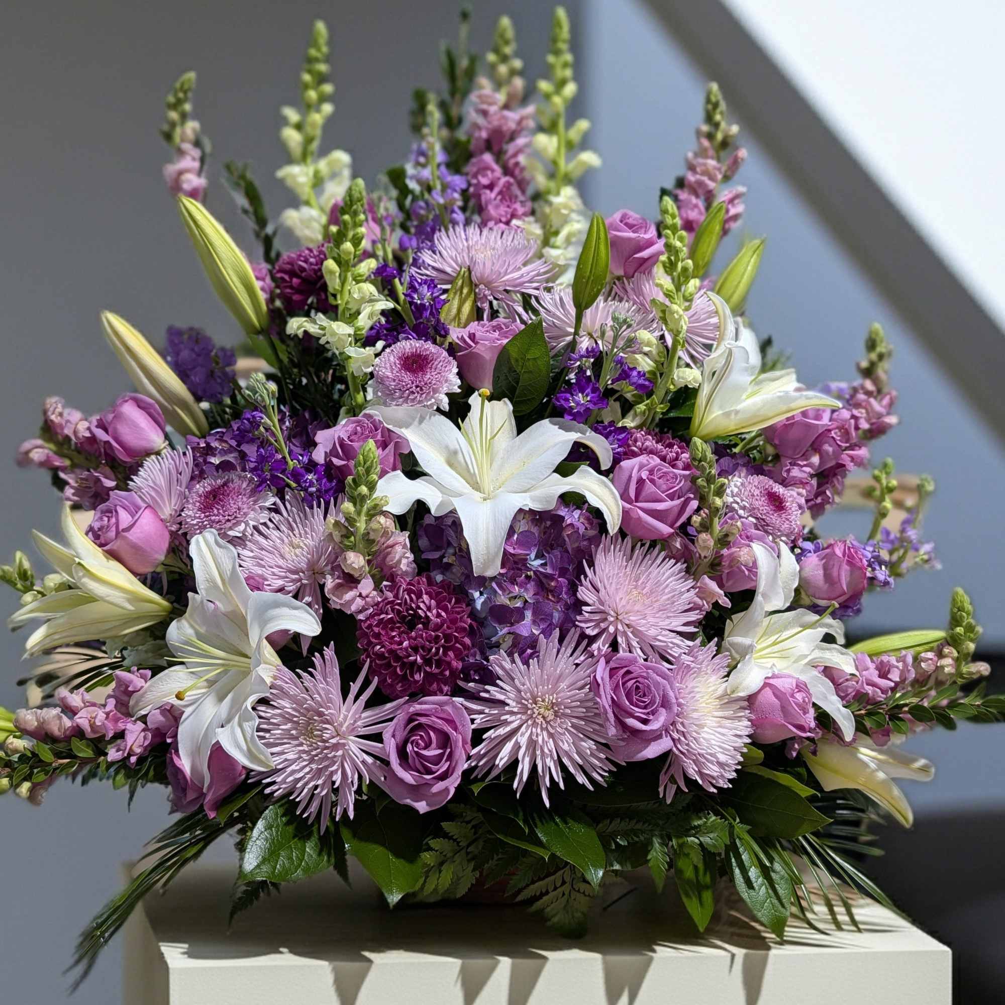 Lavender and white bouquet with lilies and roses in a low arrangement