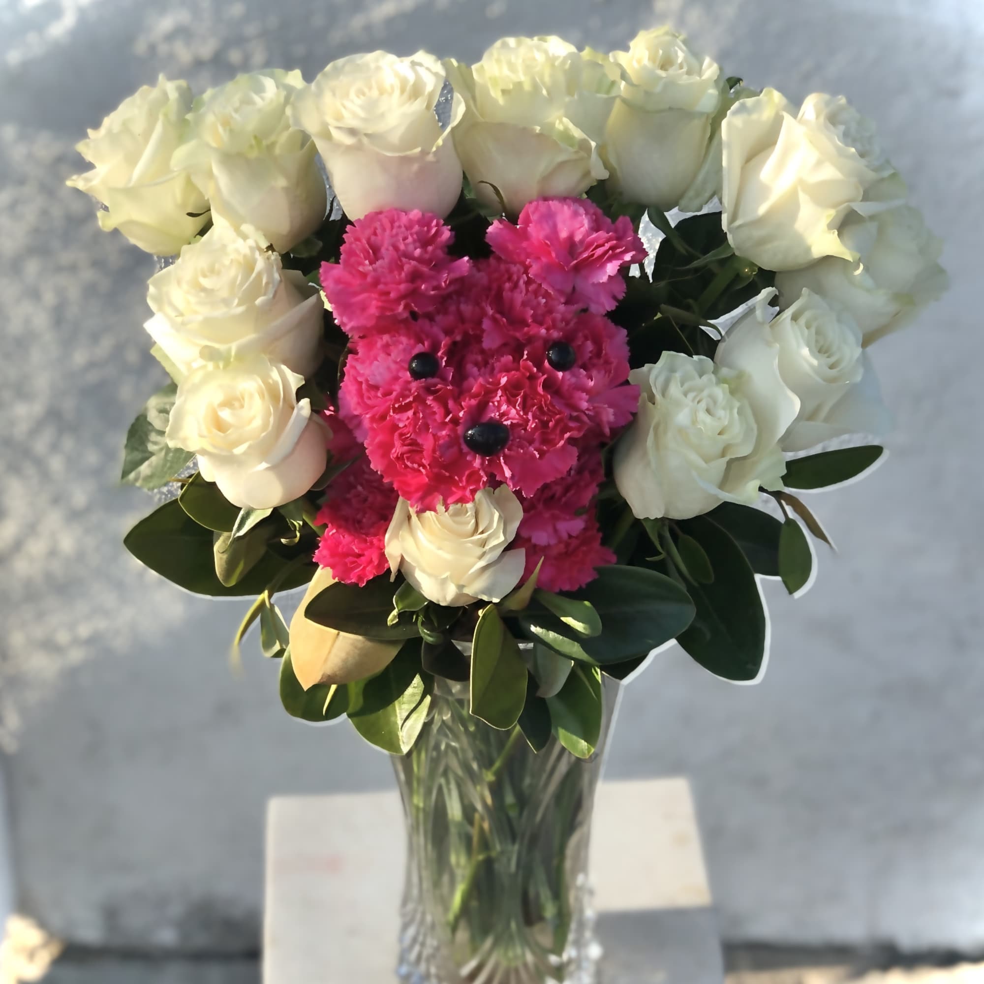 Bouquet of white roses and bright pink flowers in a glass vase
