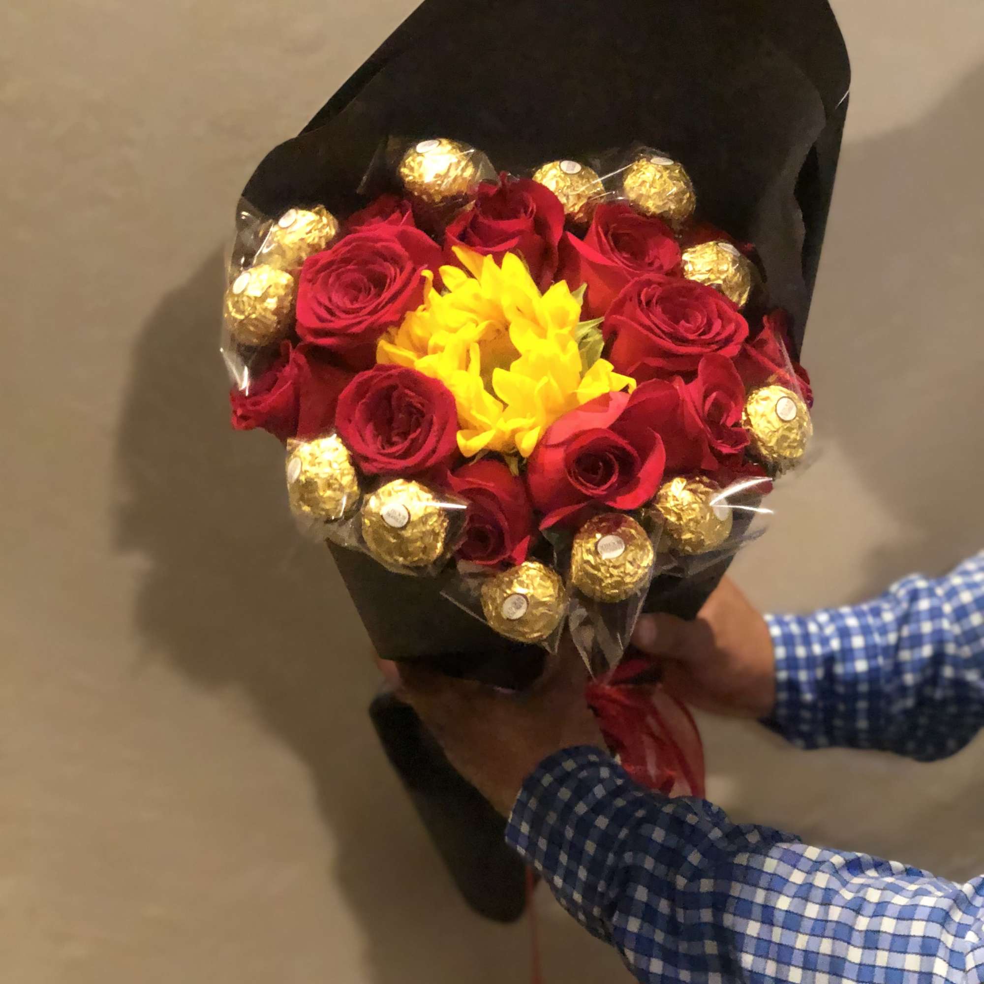 Bouquet of red roses with yellow flowers and gold-wrapped chocolates
