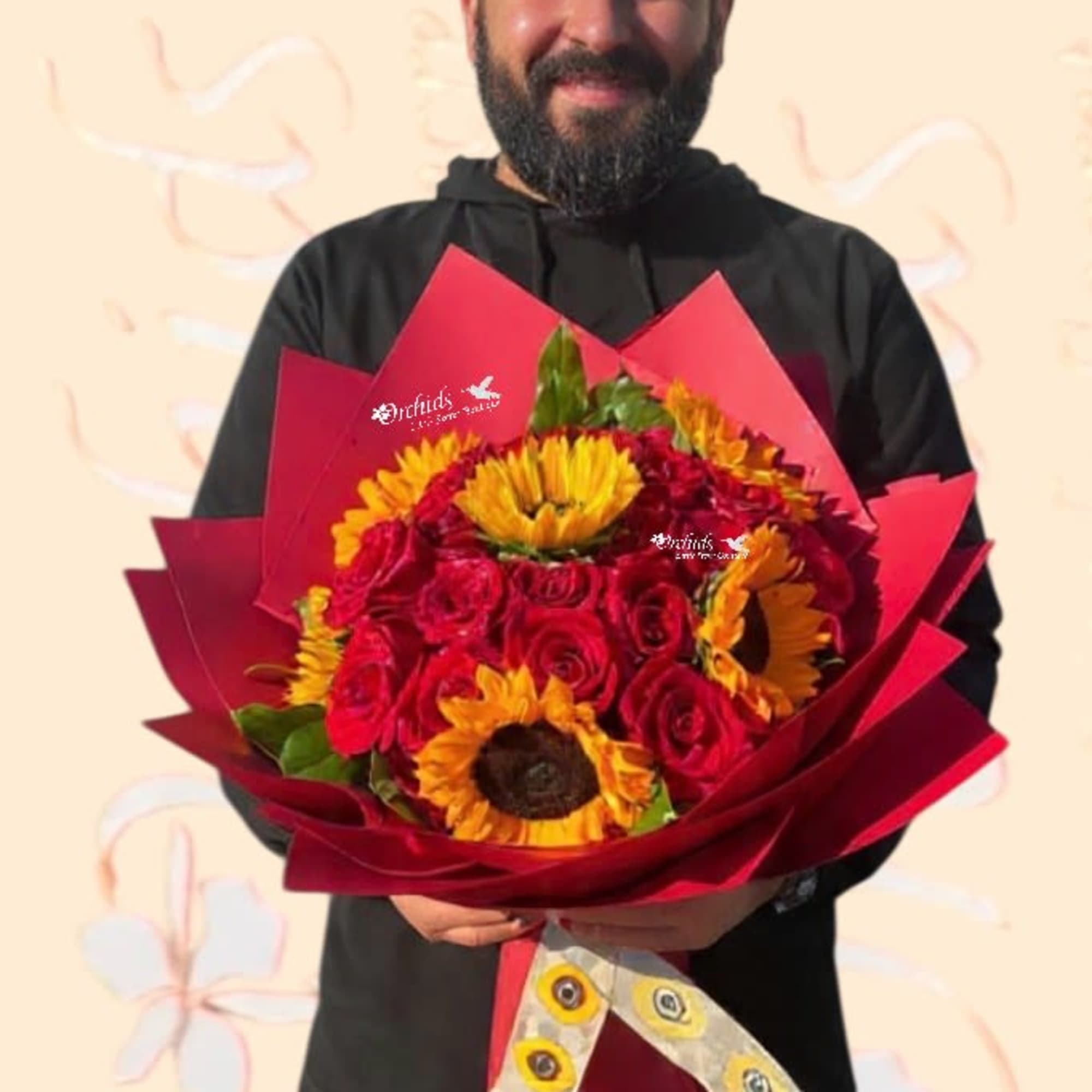 Man holding a bouquet of red roses and yellow sunflowers wrapped in red paper