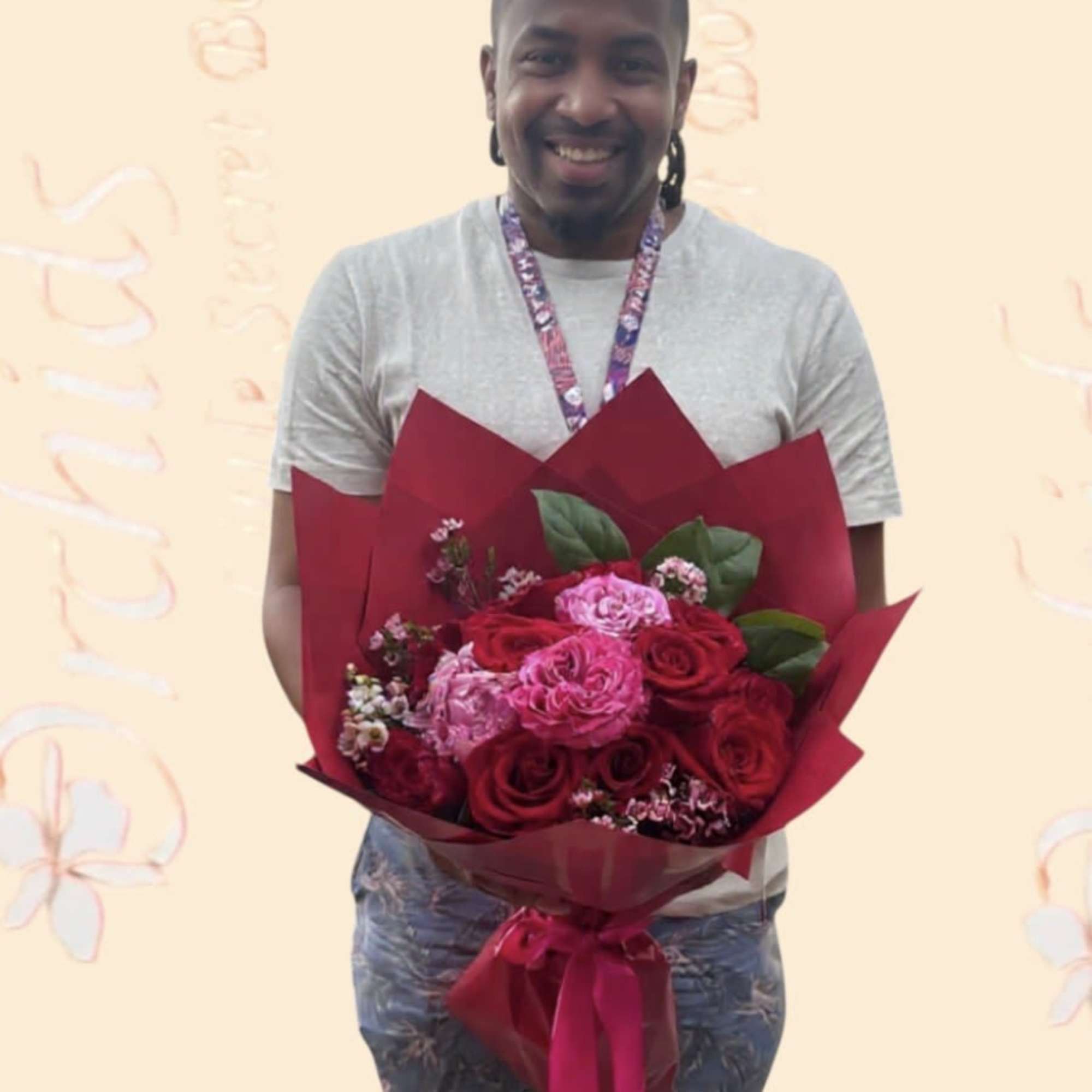 Man holding a bouquet of red and pink roses wrapped in burgundy paper