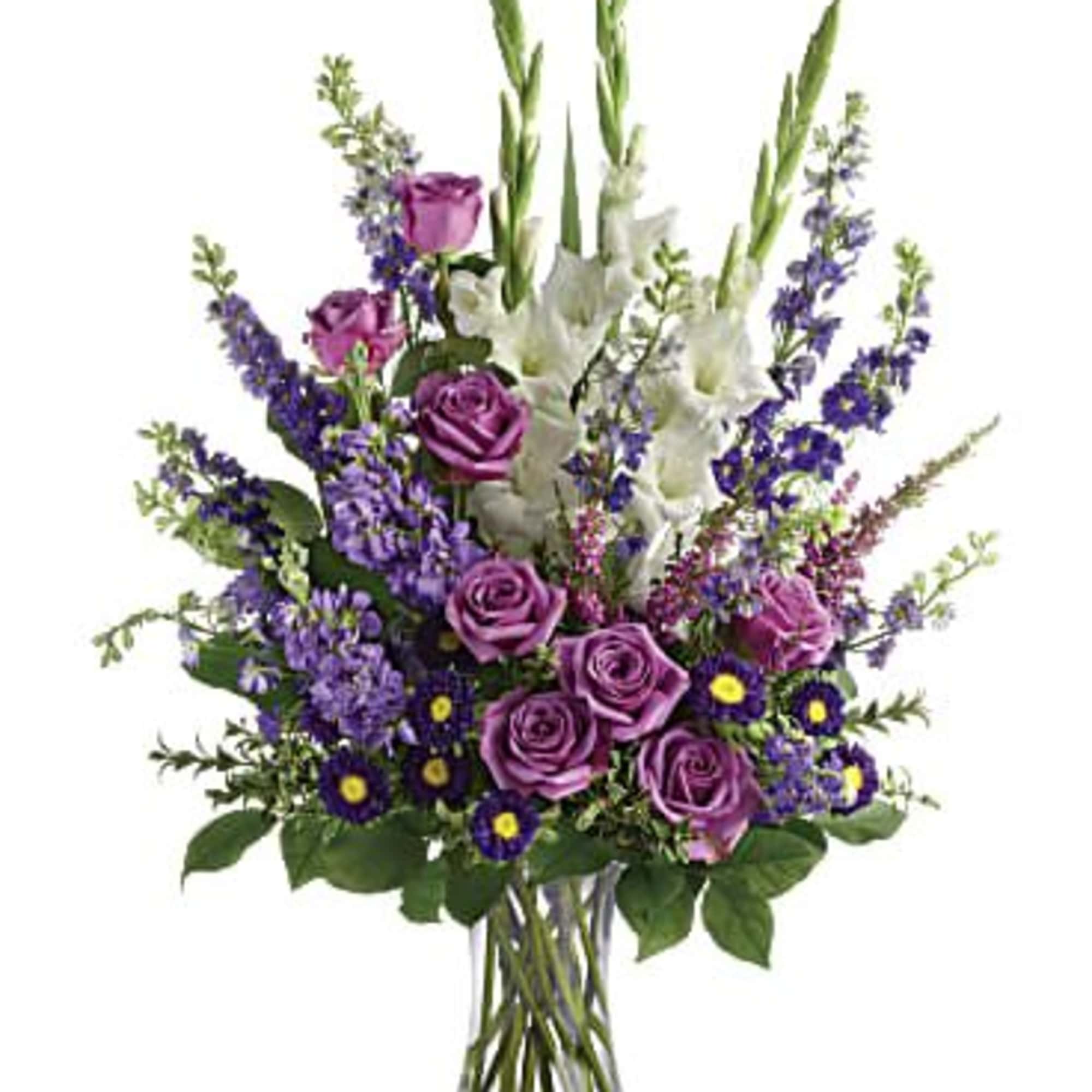 Purple roses and white gladiolus in a clear glass vase