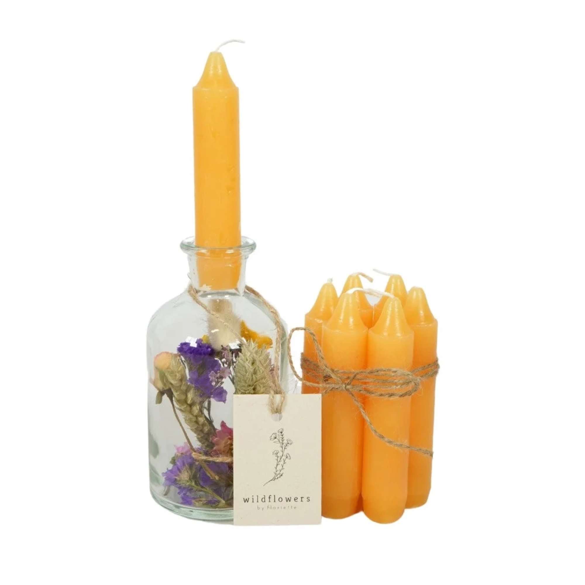 Orange candles with a glass bottle of dried flowers