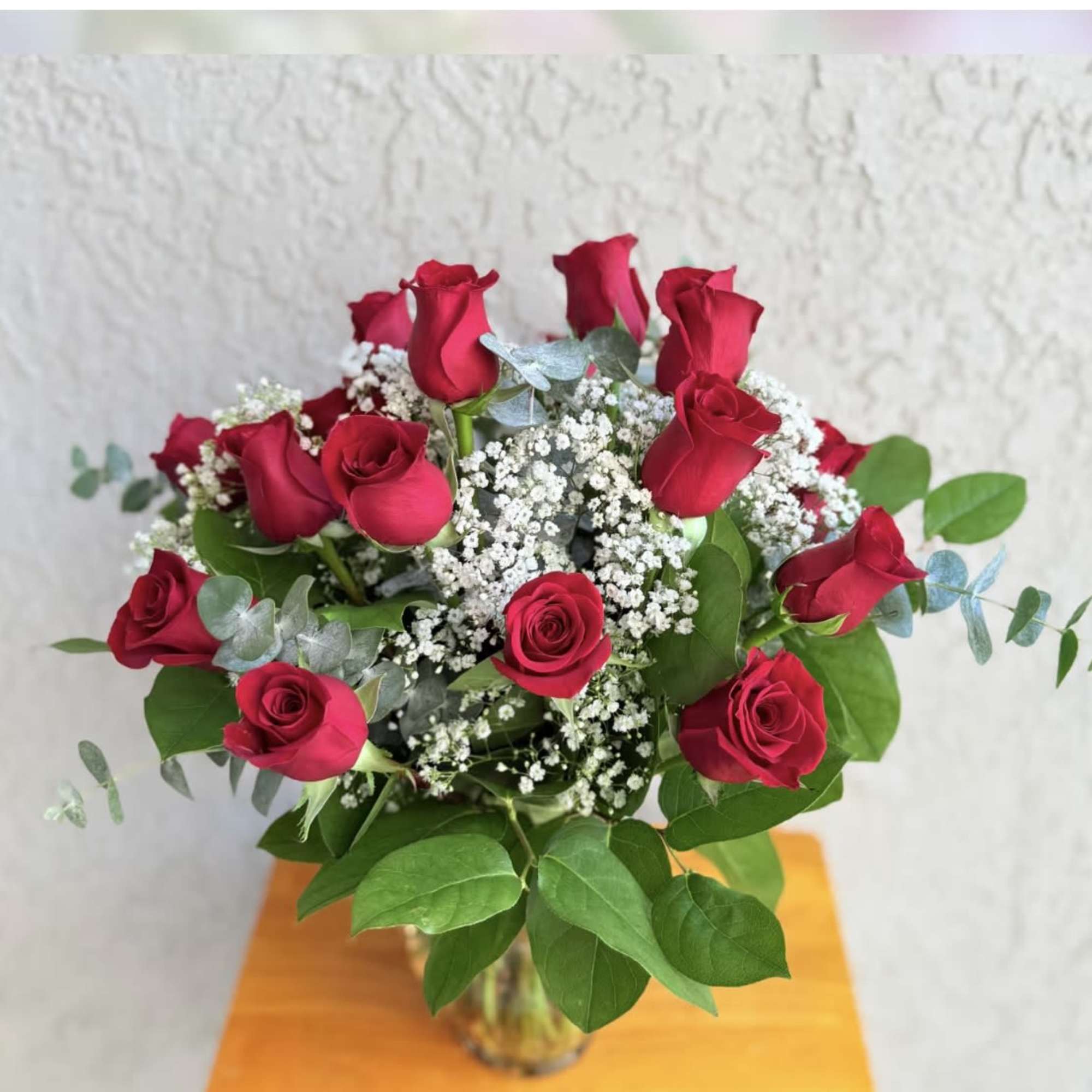 Bouquet of red roses with white baby's breath in a glass vase