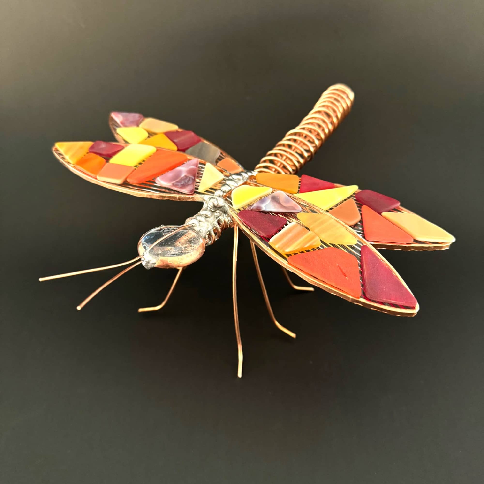 A playful, handcrafted dragonfly accent that brings warm, autumnal color to any