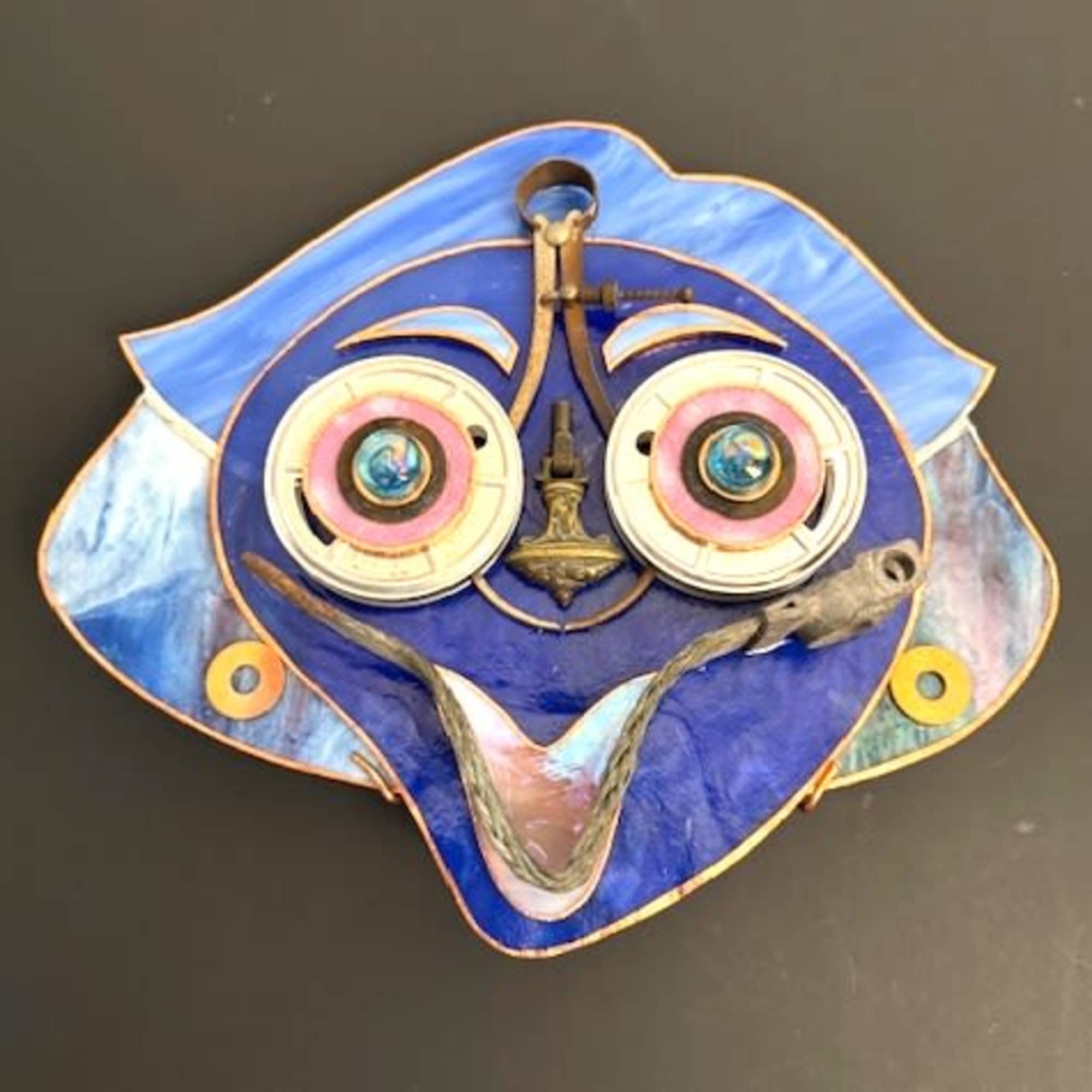 A bright, playful face in vivid blue tones greets the room-this mixed-media