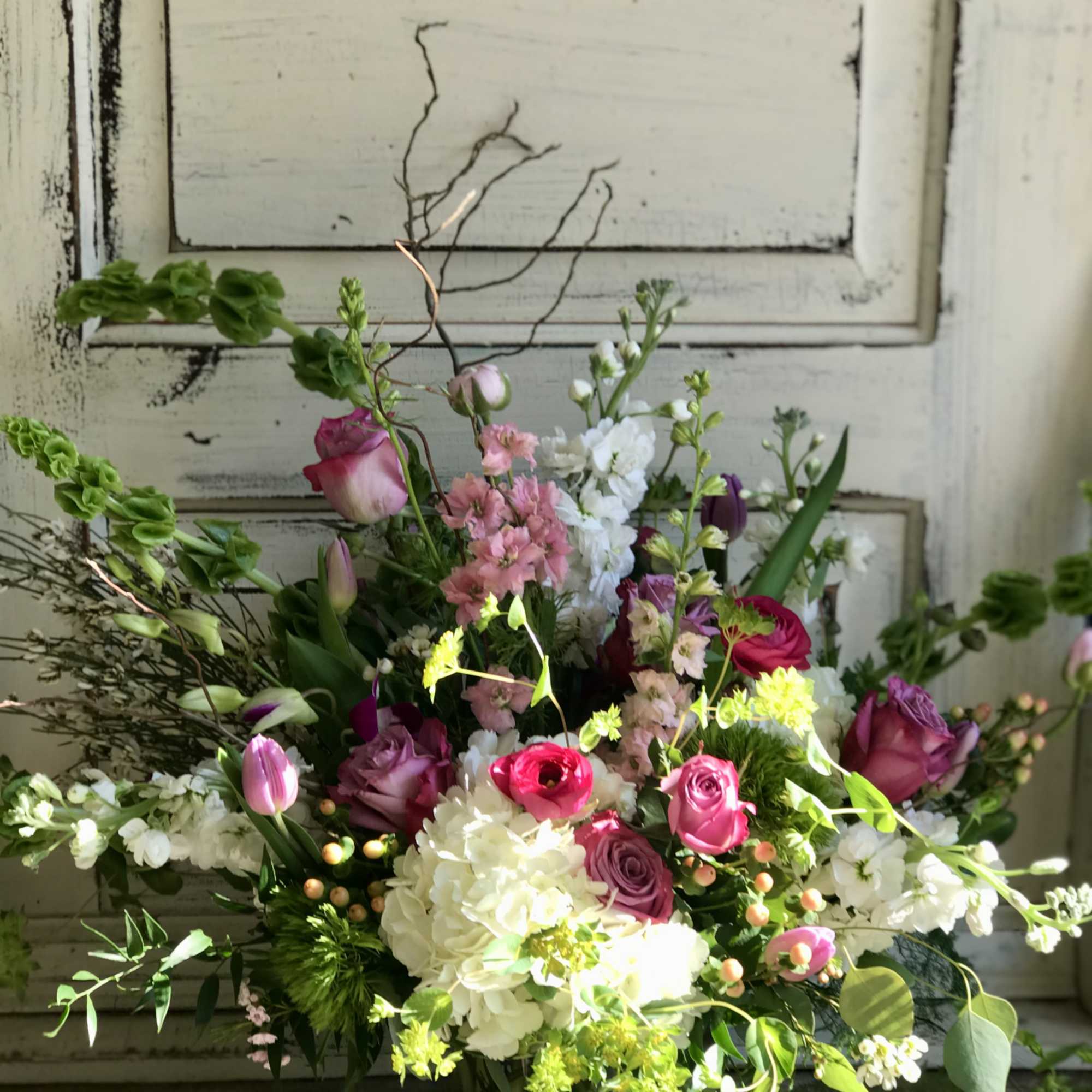 Mixed bouquet of pink, white, and purple flowers in a glass vase