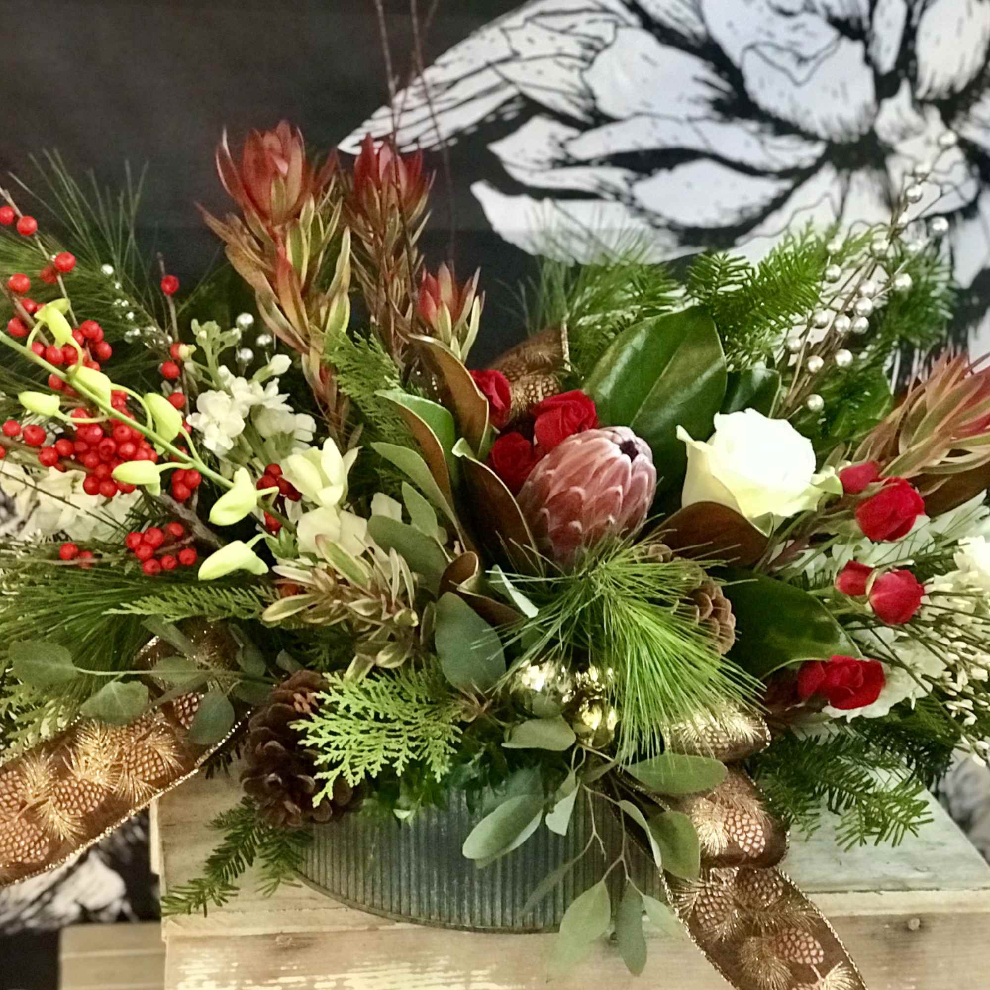 Festive floral arrangement with red berries and white blooms in a container