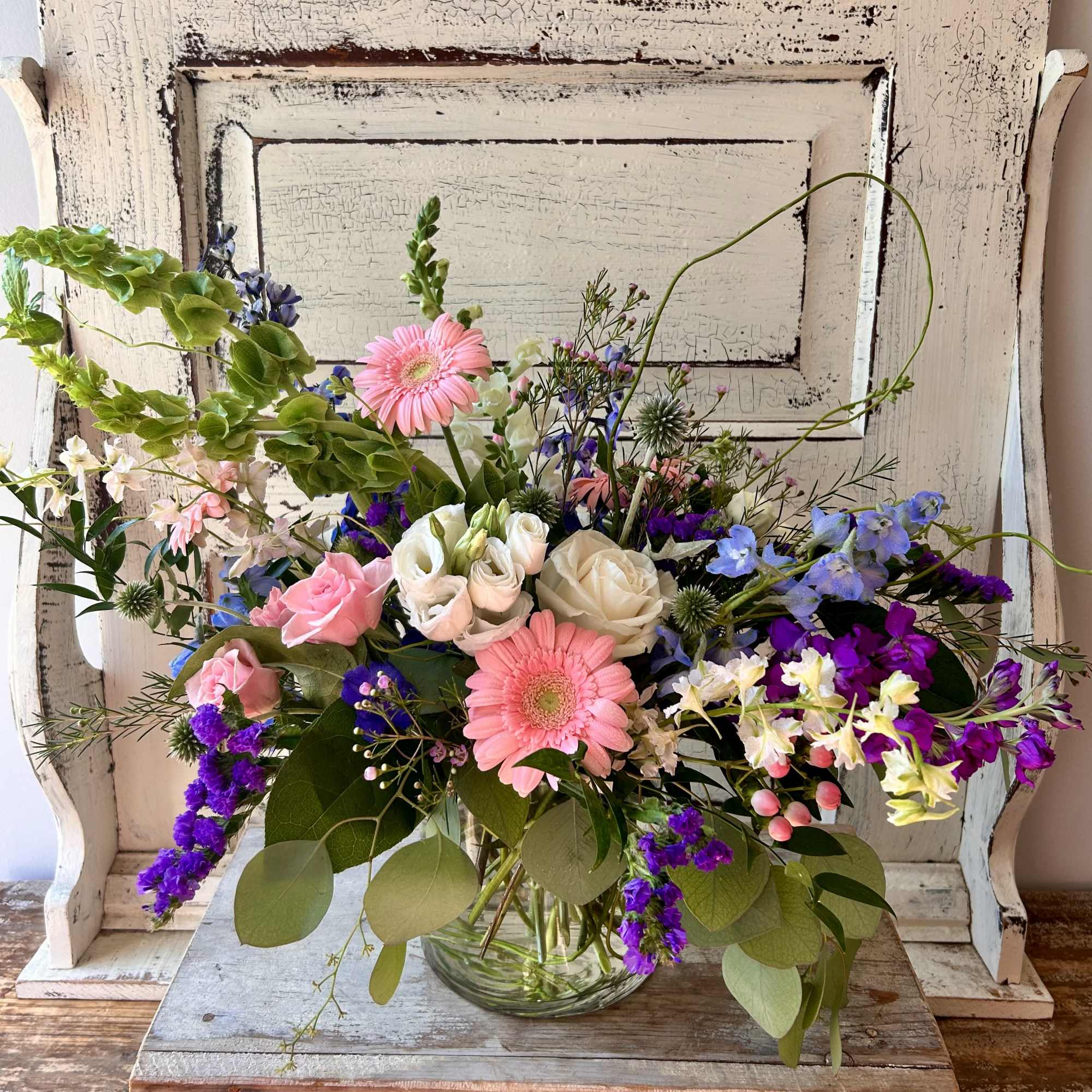 Mixed bouquet of pink, white, and purple flowers in a glass vase