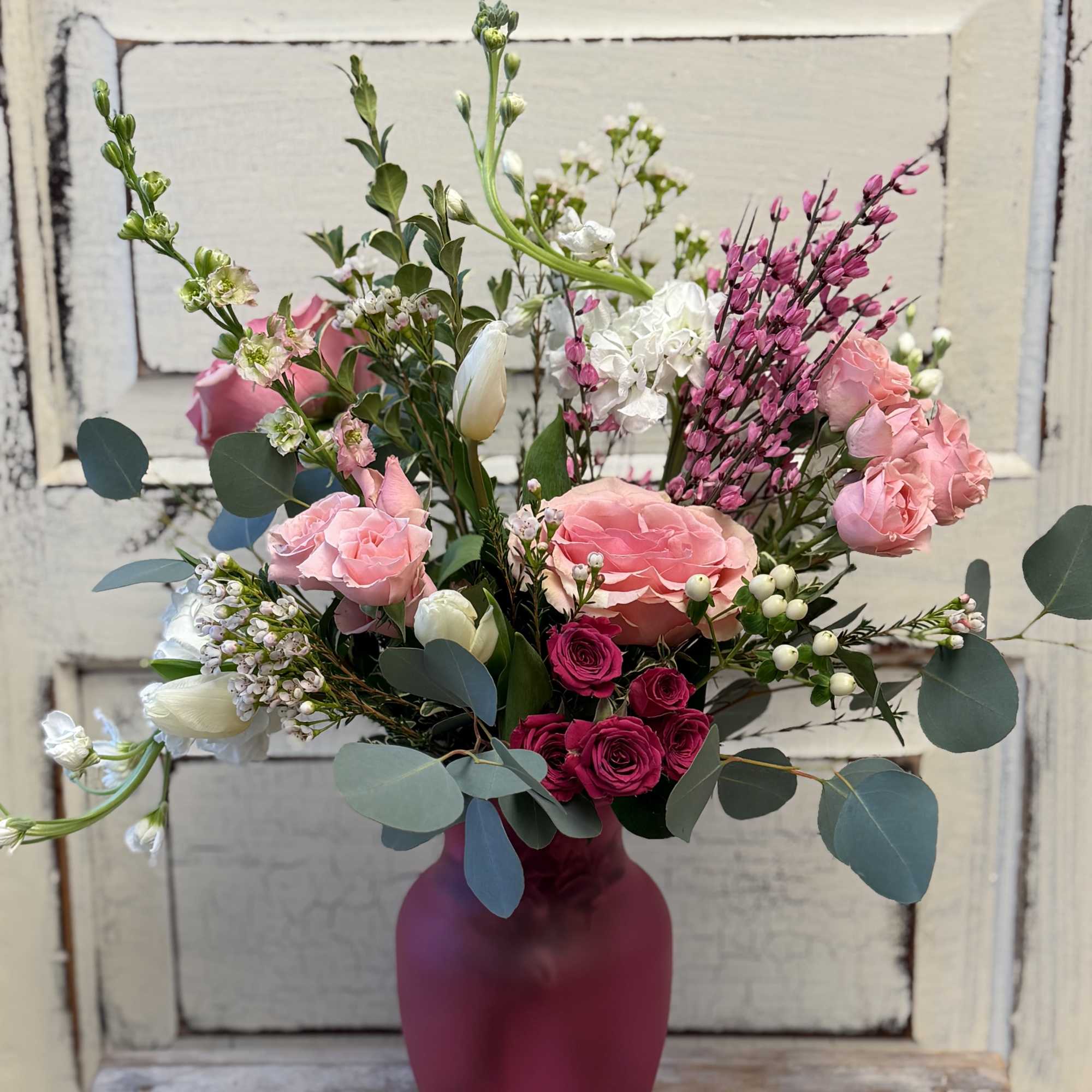 Pink and white mixed bouquet in a magenta vase