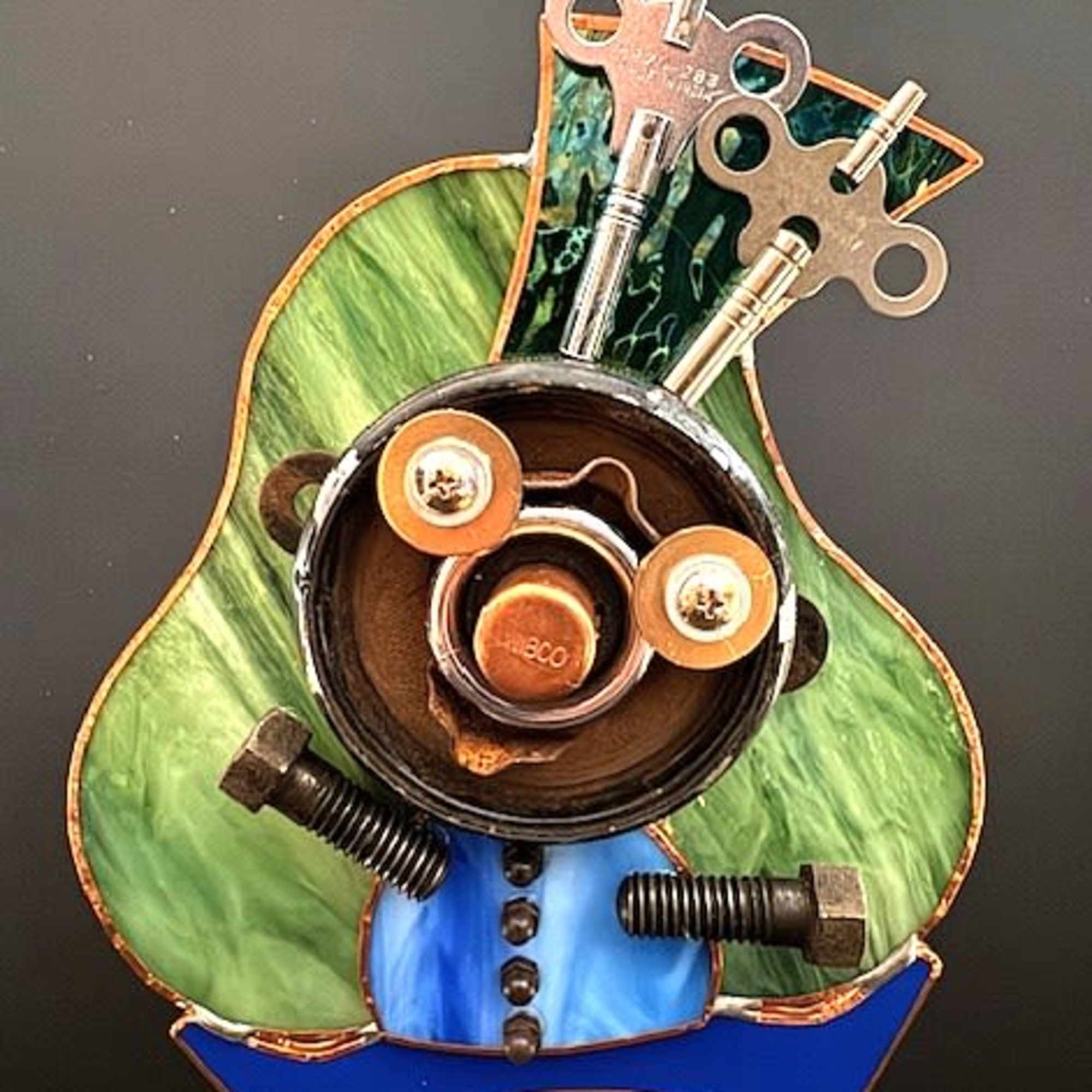 Swirled green stained glass forms the cheerful torso of this small mixed-media