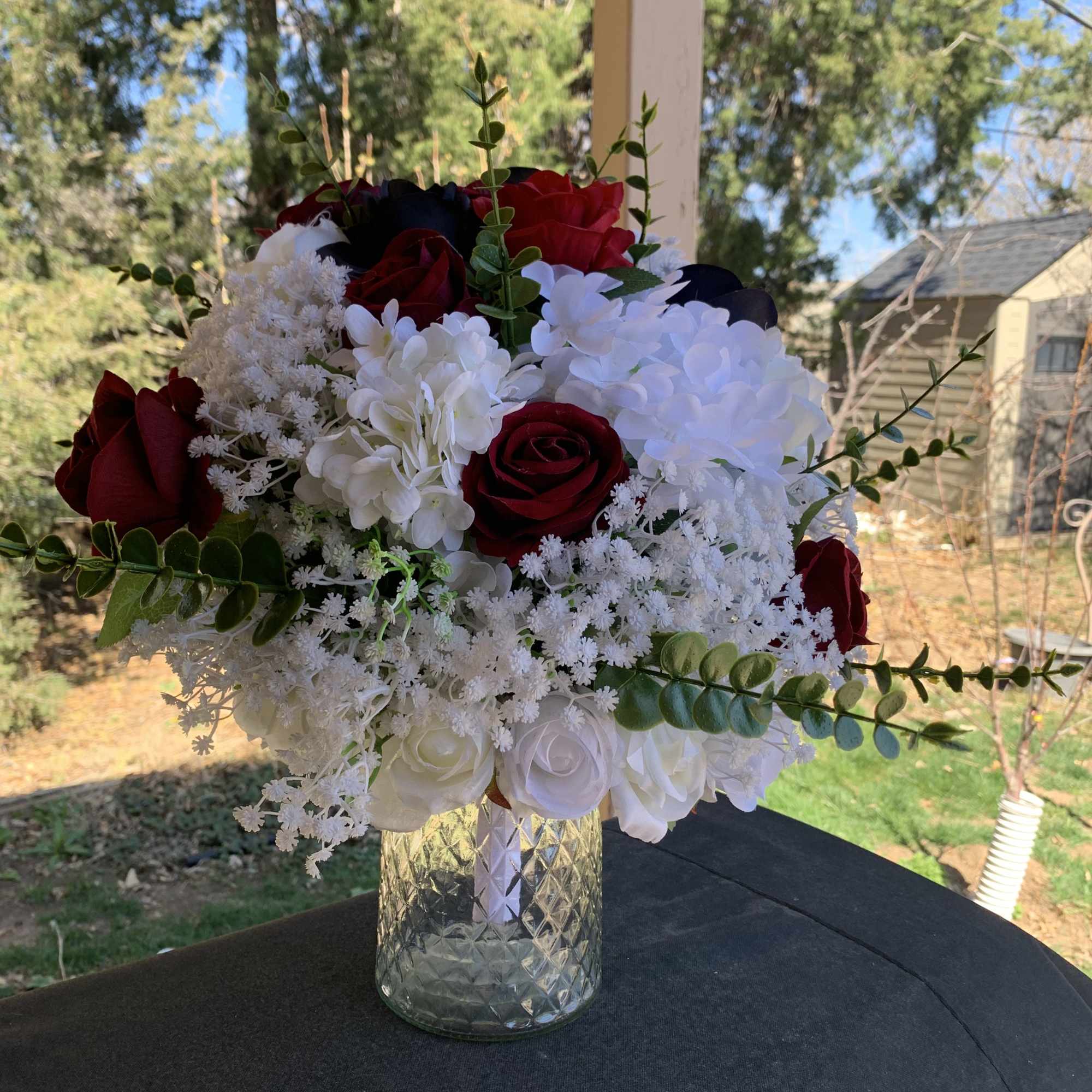 Deep red roses set against clouds of white hydrangea and delicate baby's