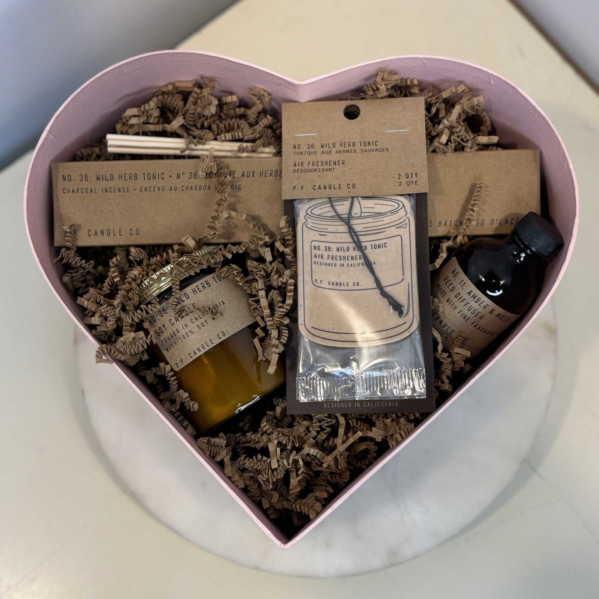 Heart-shaped gift box with candles and air freshener packets