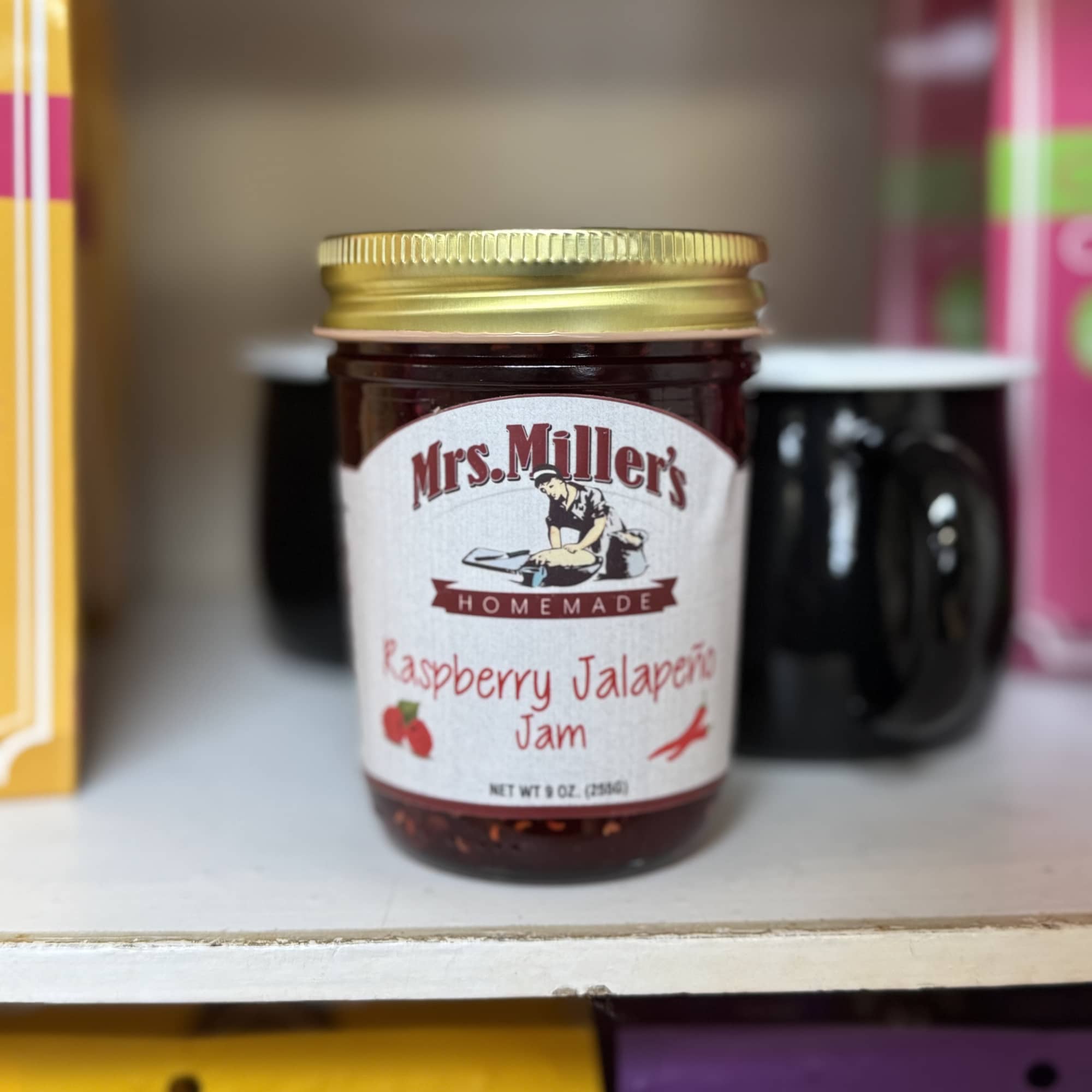 Jar of raspberry jalapeño jam with a gold lid