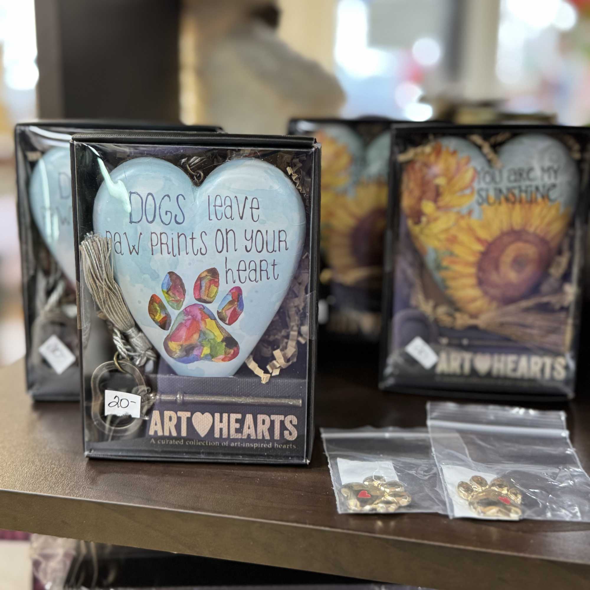 Gift box with a heart ornament reading "Dogs leave paw prints on your heart"