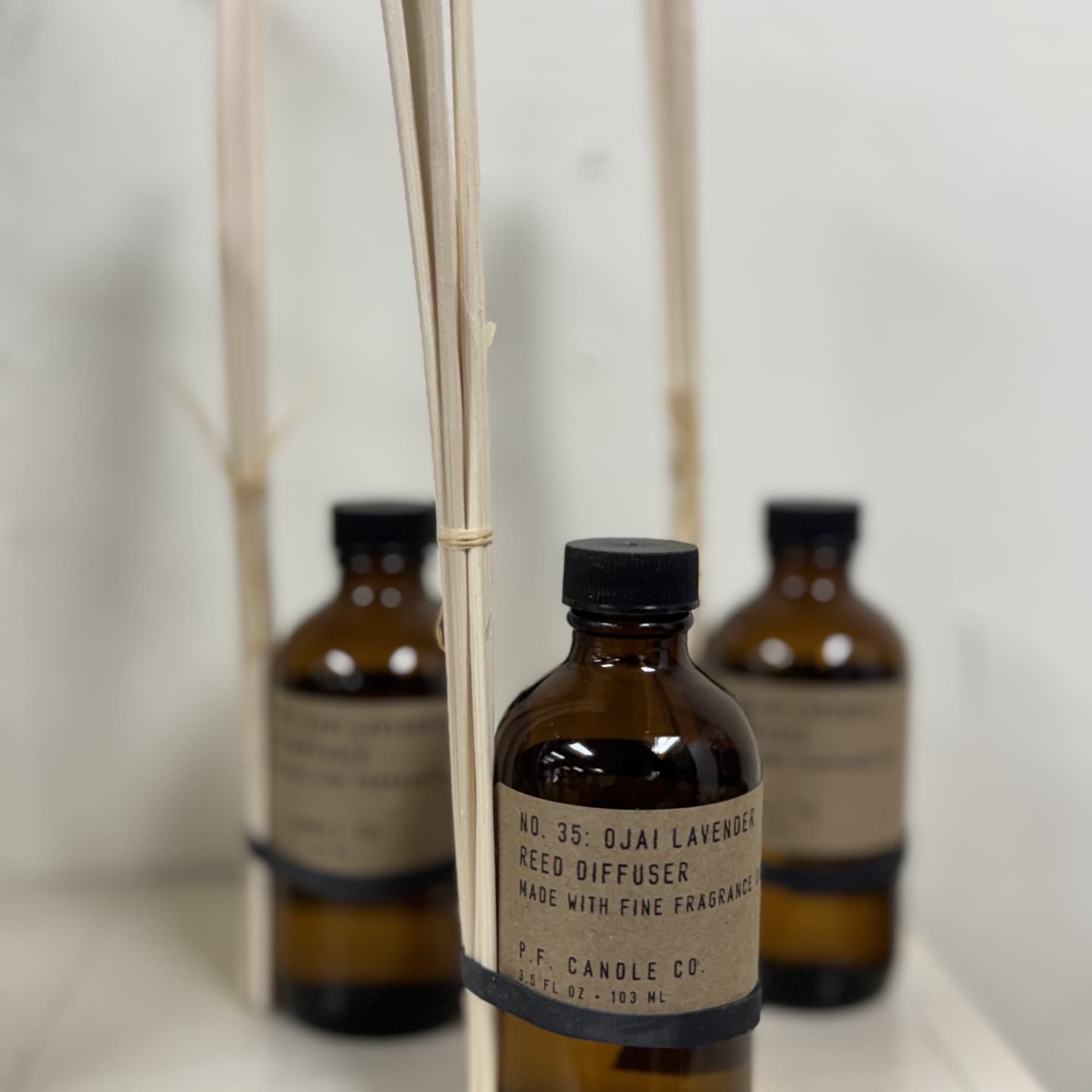 Amber reed diffuser bottles with black caps and reed sticks