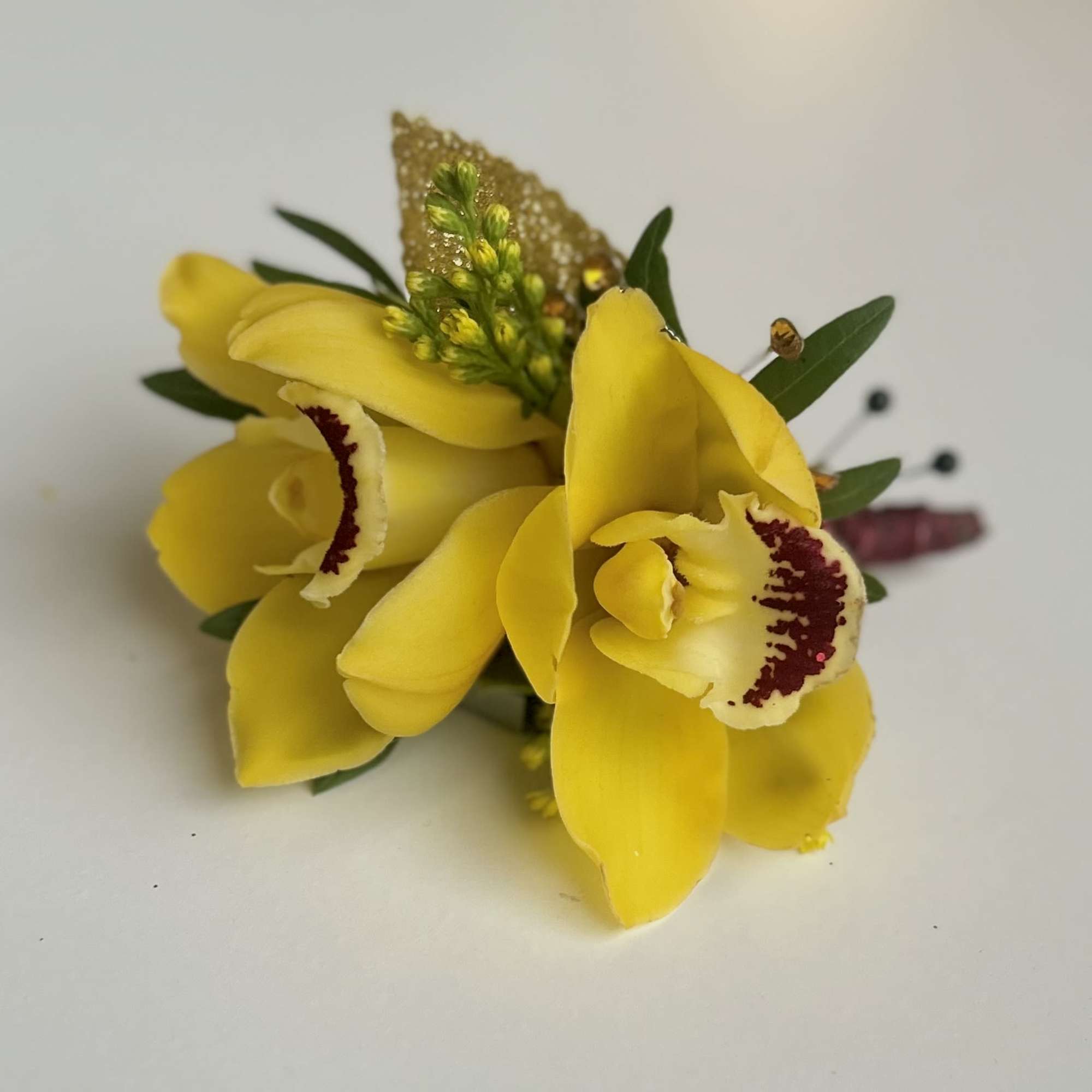Yellow orchid corsage with small green accents