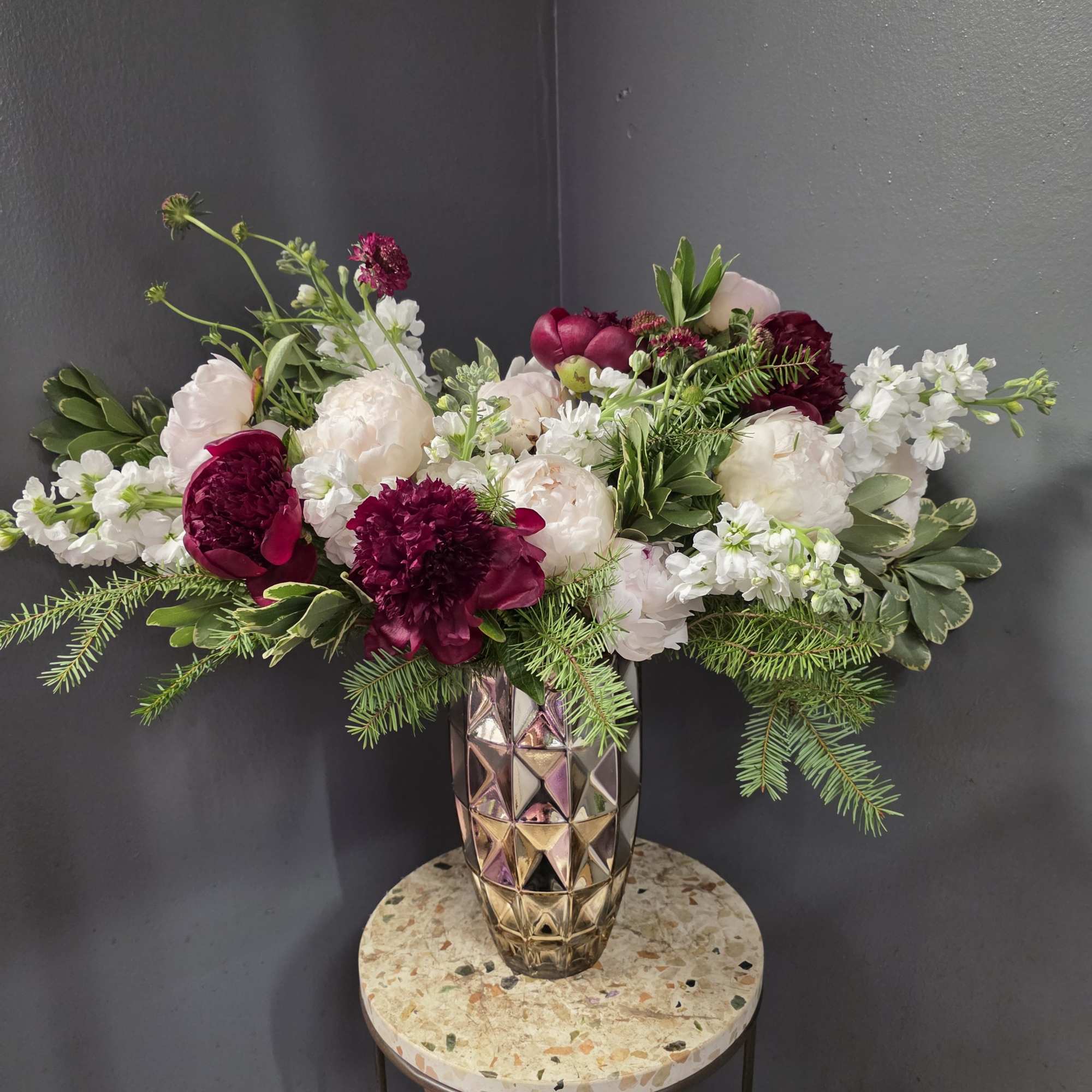 Bouquet of white and deep pink flowers in a faceted metallic vase