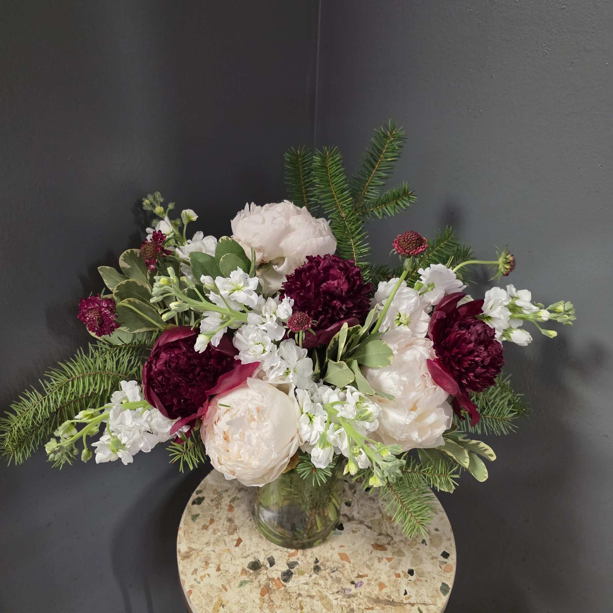 Bouquet of white and deep burgundy flowers in a glass vase