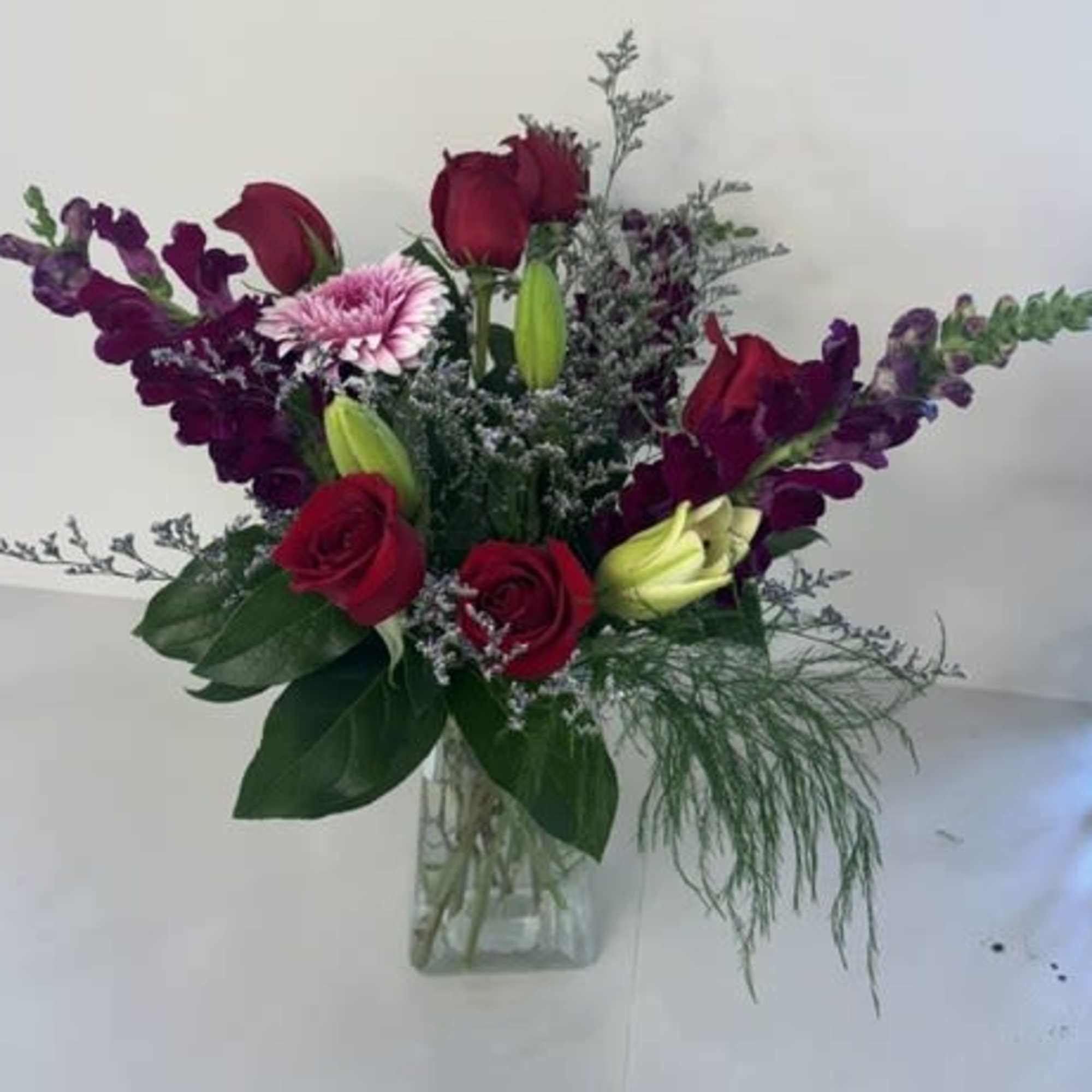 Garden of Devotion is a romantic garden-inspired arrangement featuring rich red roses