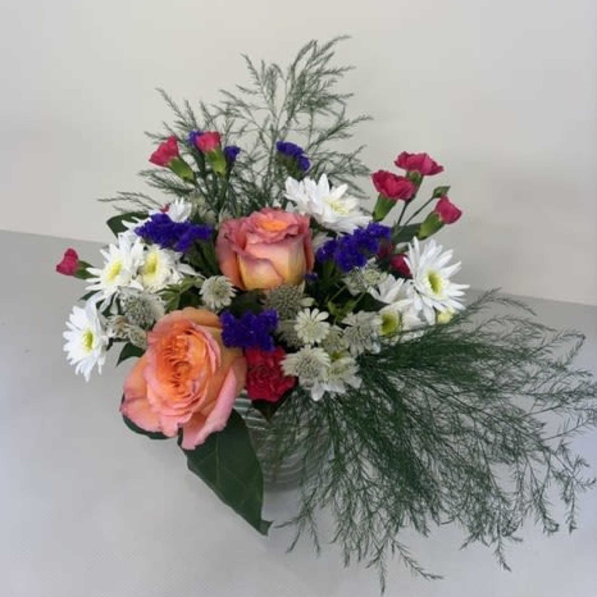 Daisy Dream Delight is a whimsical, garden-inspired arrangement featuring cheerful white daisies
