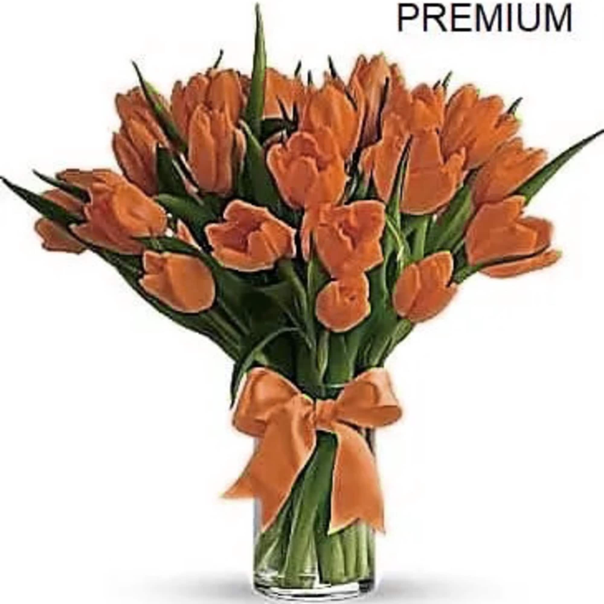 Arrangement of orange tulips in a clear glass vase with an orange bow