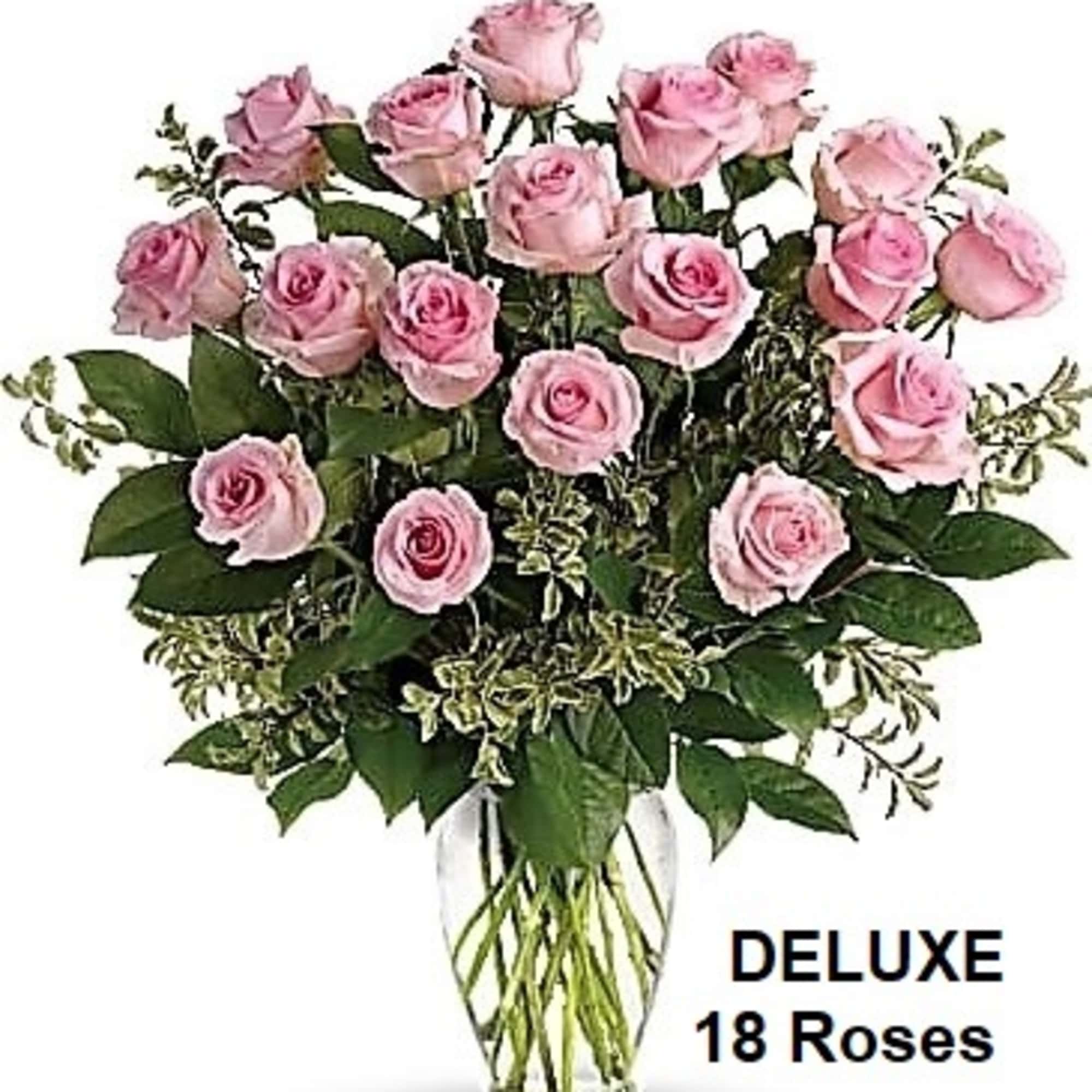 Tall arrangement of light pink roses in a clear glass vase
