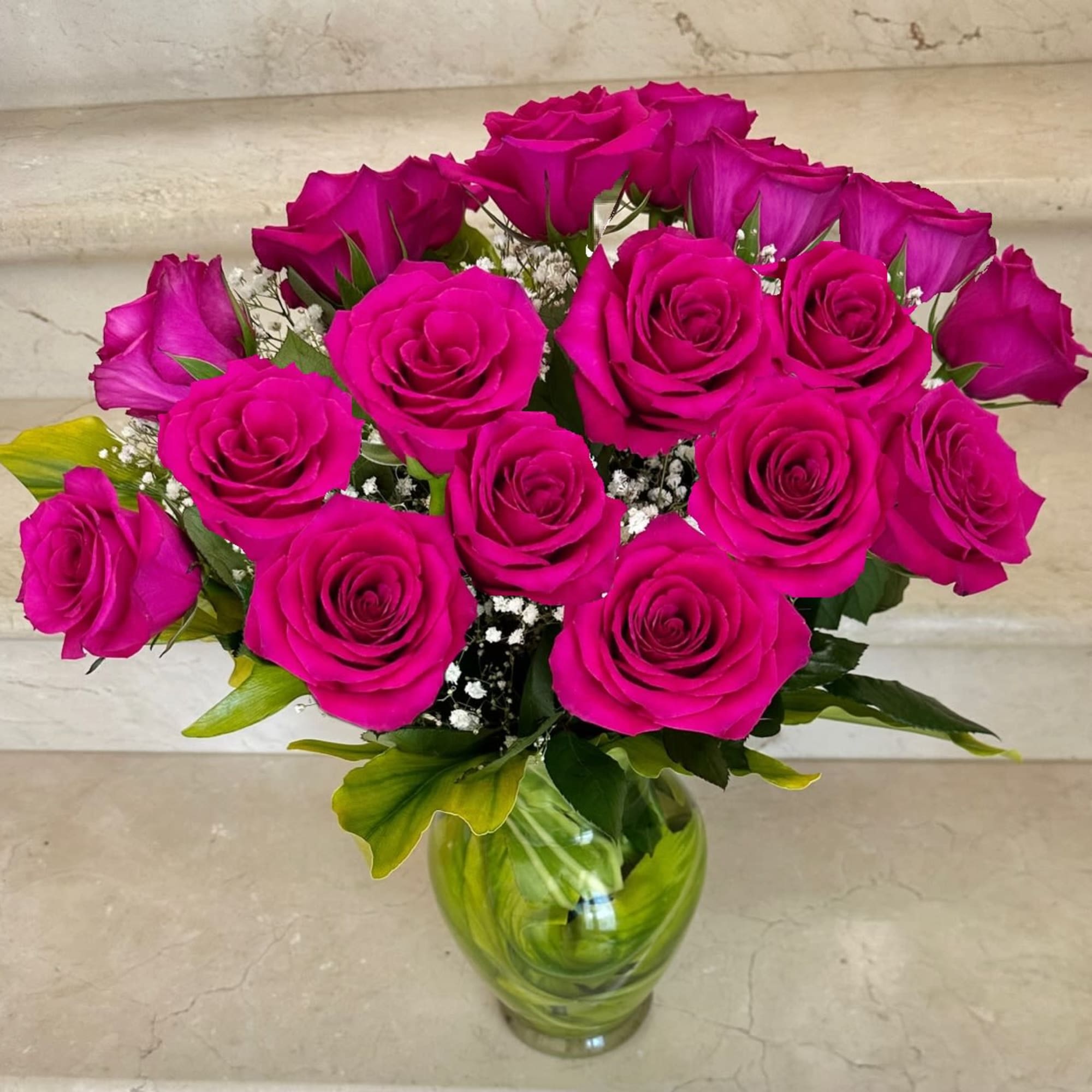 Bouquet of bright pink roses in a green glass vase