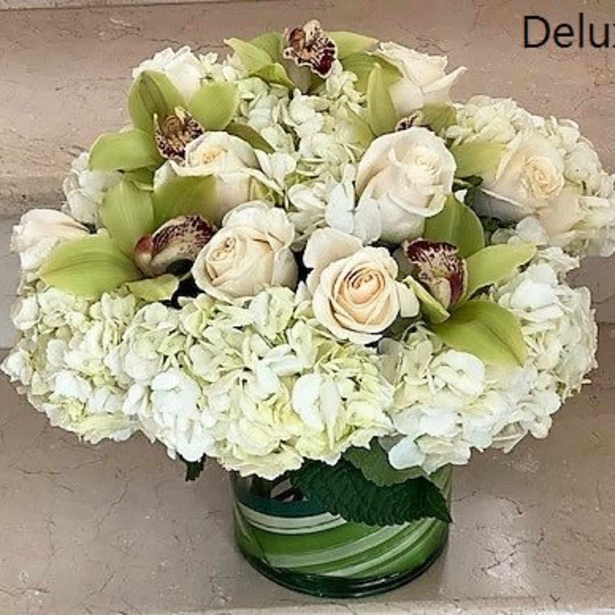 White Roses with White Hydrangeas mixed with green Cymbidium Orchid flowers. Arranged