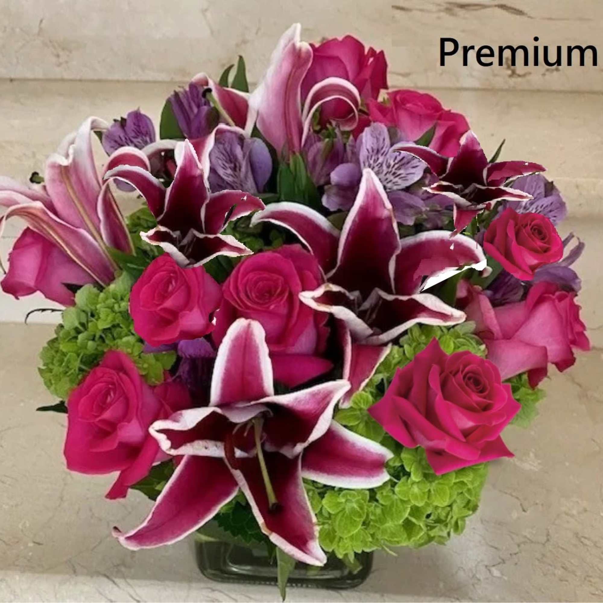 Hot Pink roses with stargazer Lilies and Hydrangeas arranged in a glass