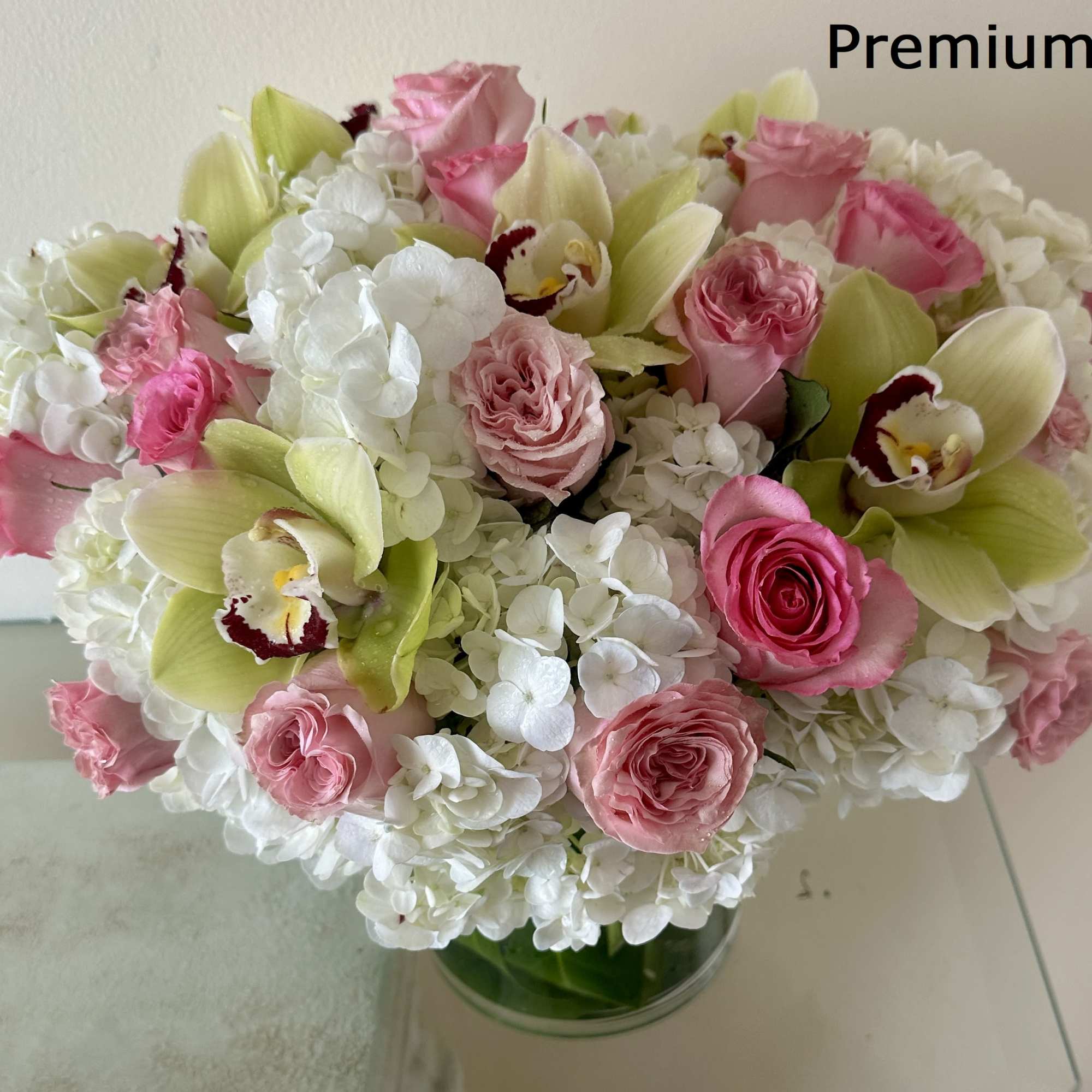 Pink roses and white hydrangeas with green orchids in a glass vase, photo 3 of 3