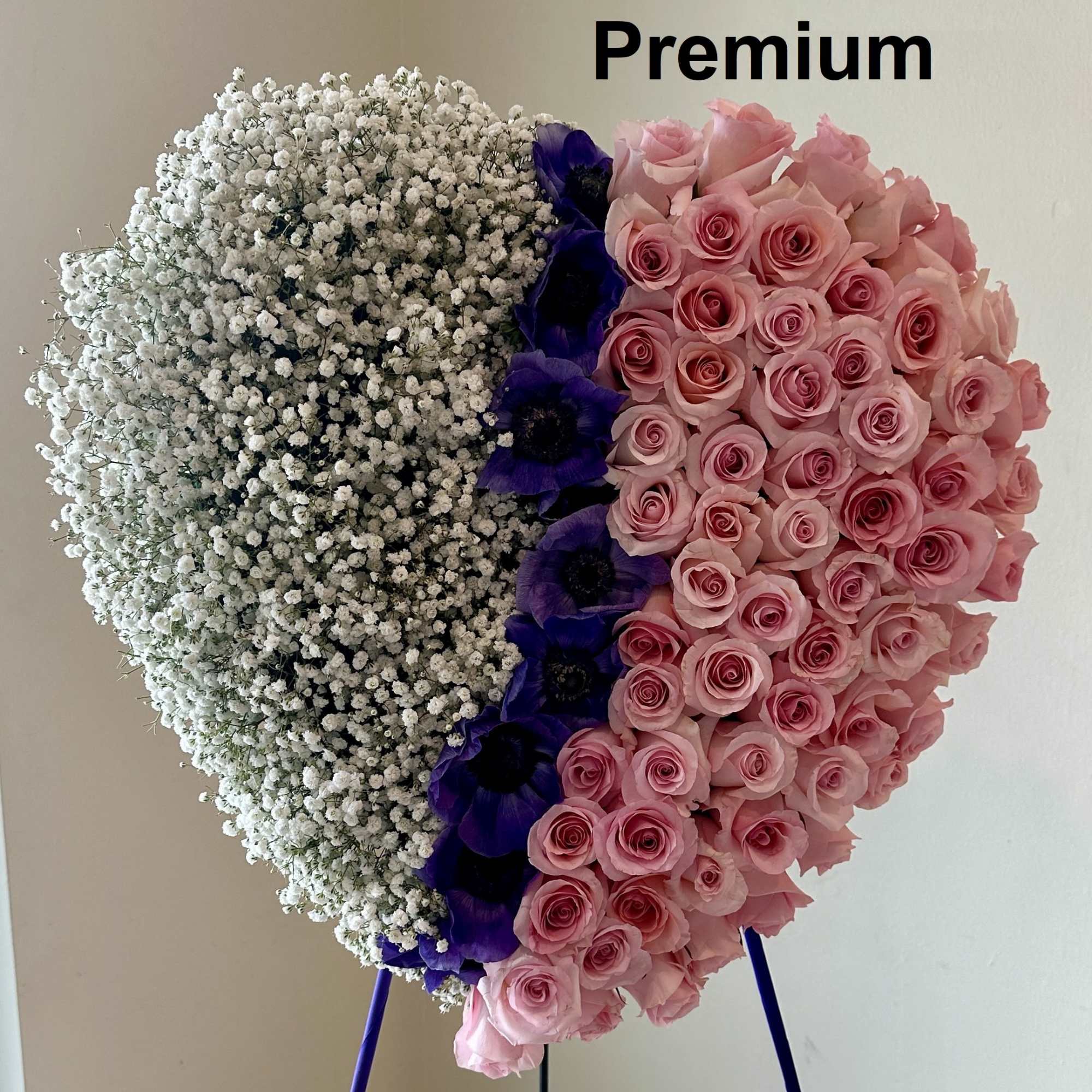 Heart-shaped standing floral arrangement with white blooms, pink roses, and purple flowers