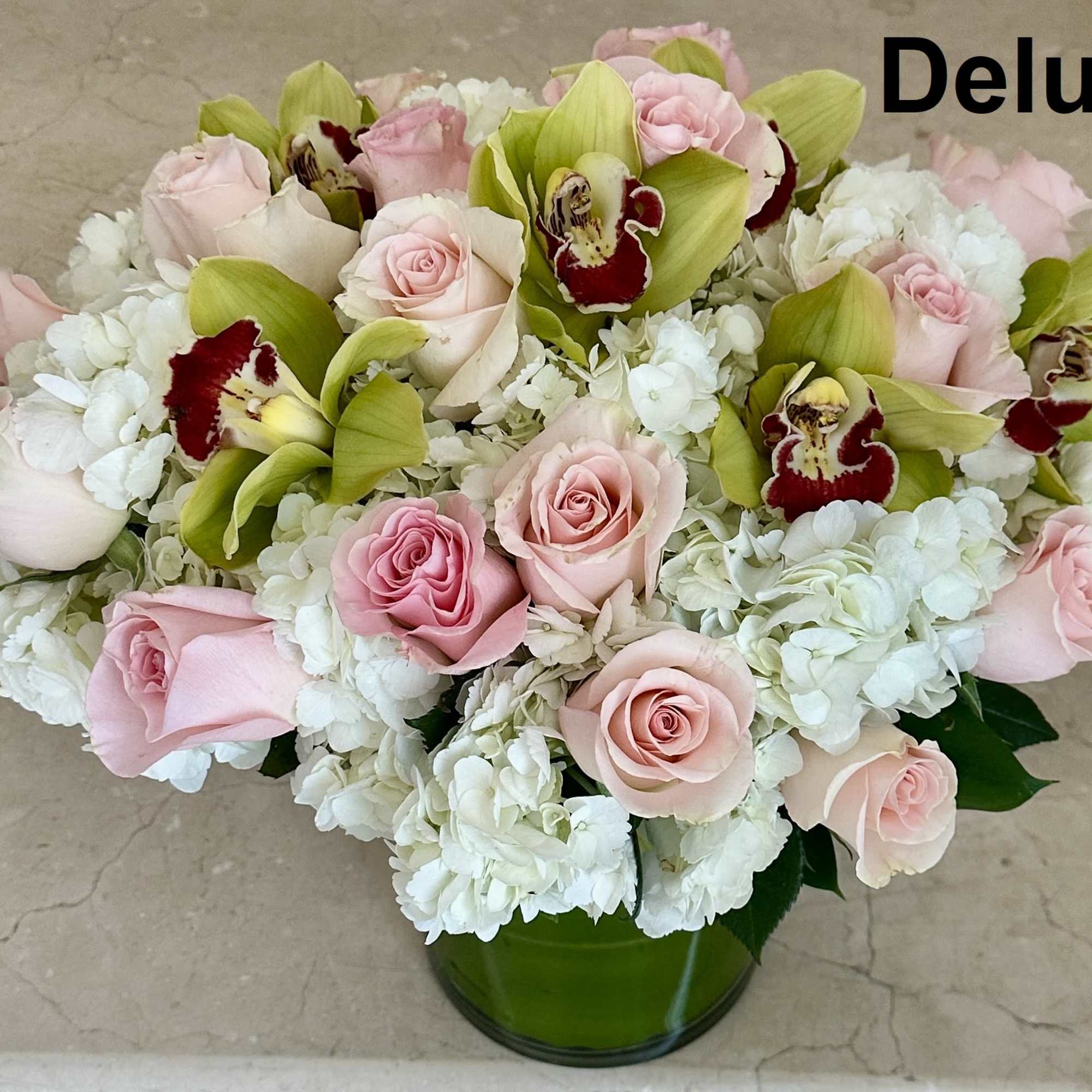Pink roses and white hydrangeas with green orchids in a glass vase, photo 2 of 3