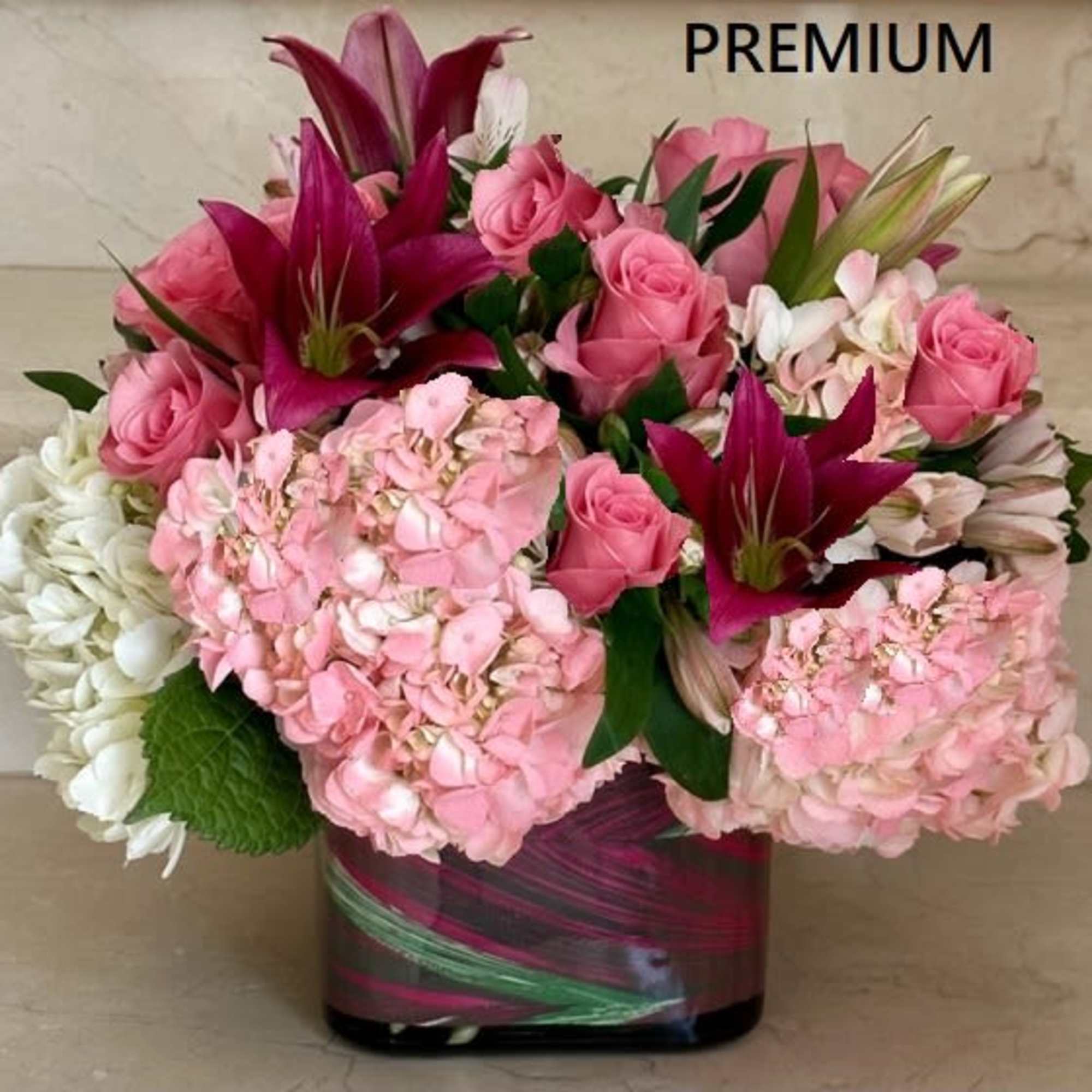 Hydrangeas, Roses, Lilies and accent flowers arranged round in a vase