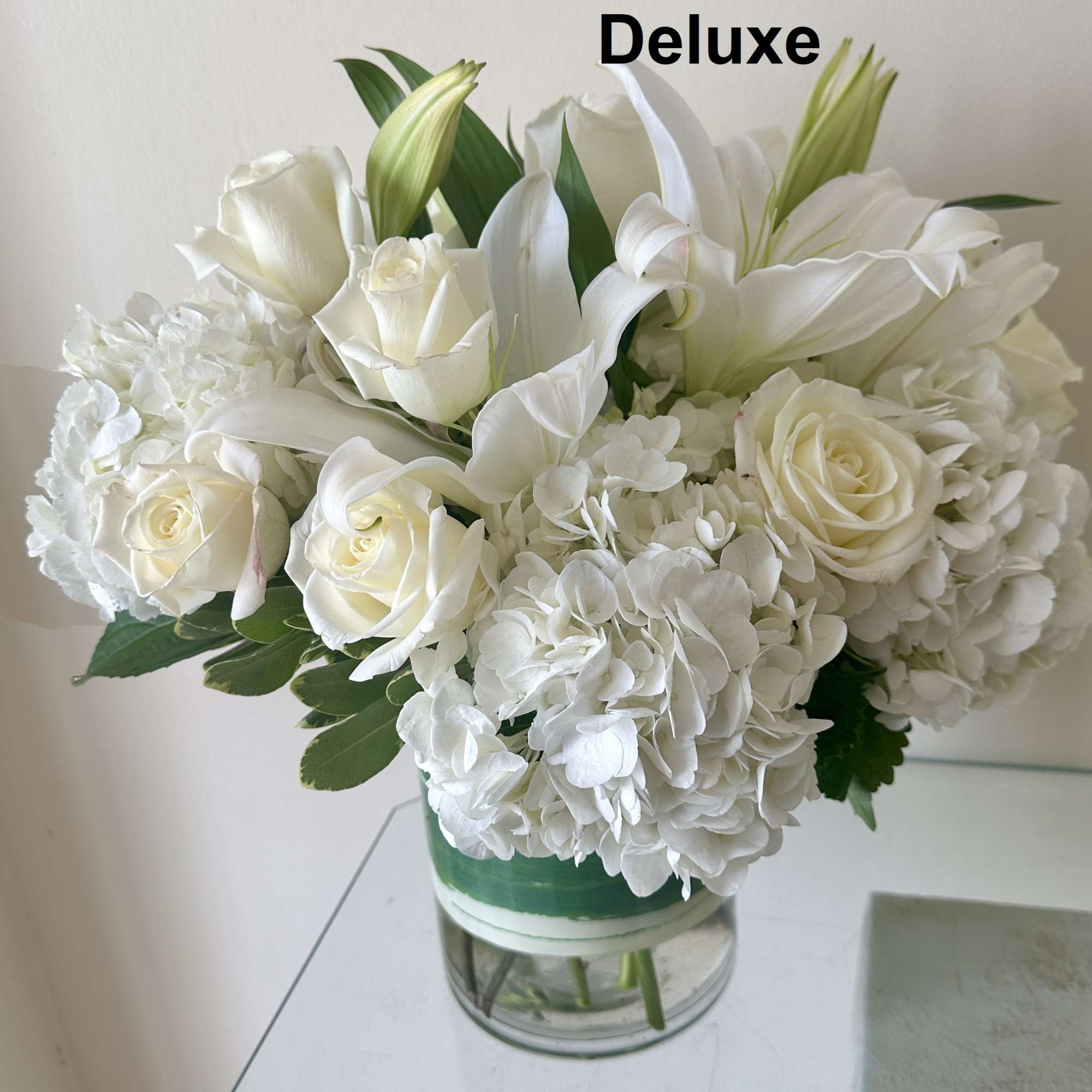 White roses and lilies arranged in a glass vase