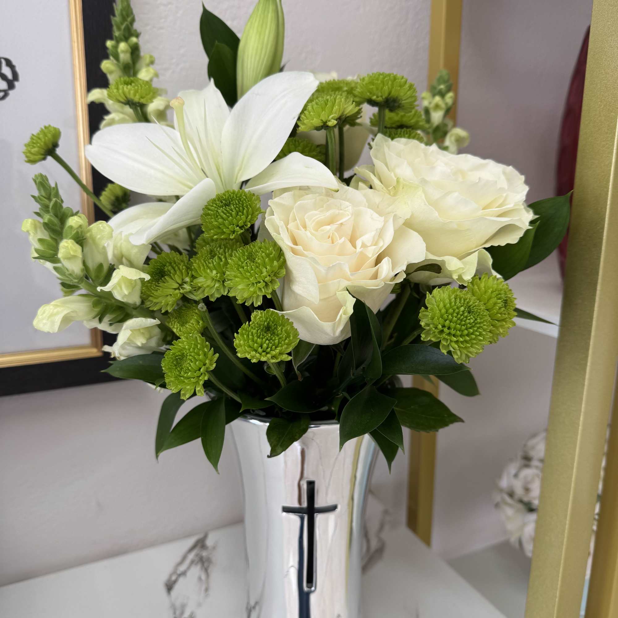 White roses and lilies with green button mums in a silver vase