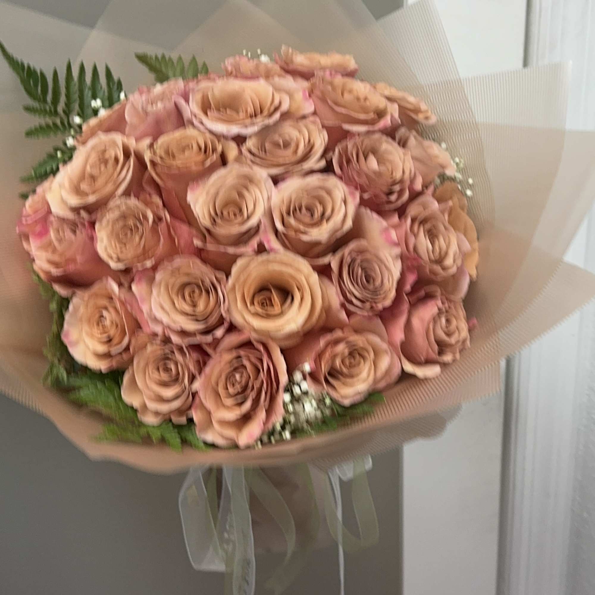 Bouquet of peach roses wrapped in translucent paper, photo 2 of 2