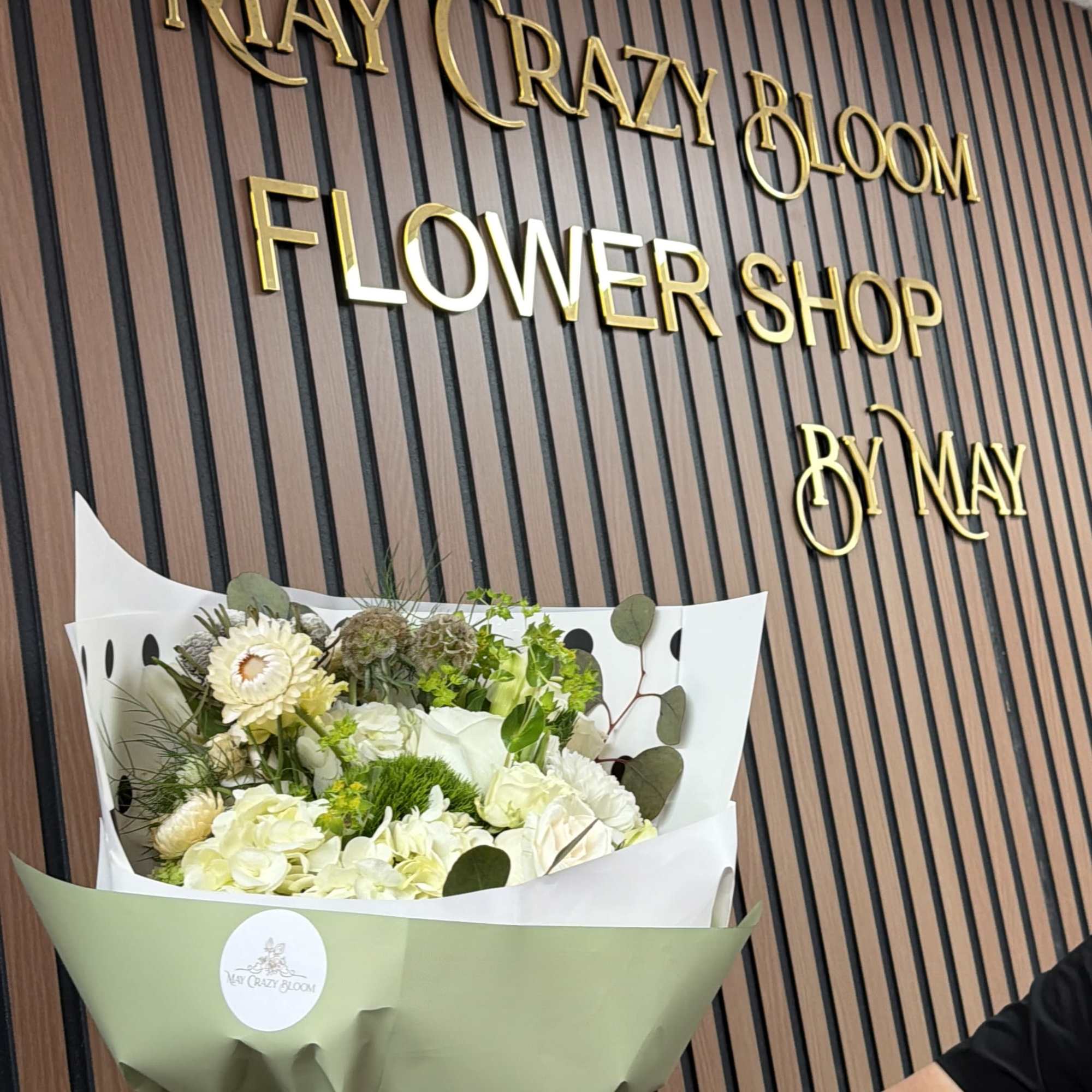 Bouquet of white flowers wrapped in pale green paper