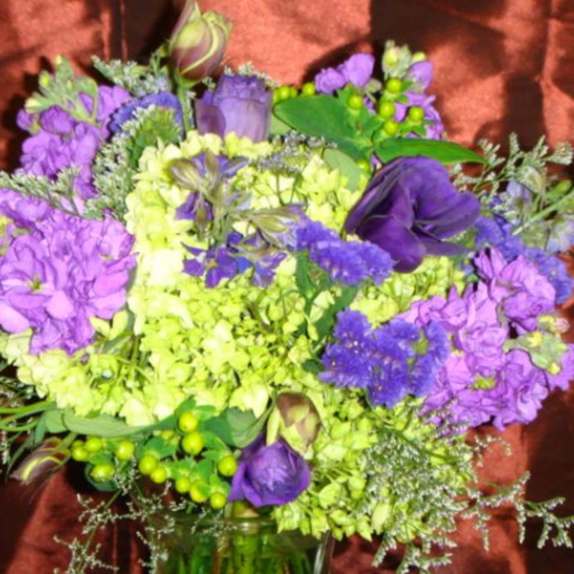 Purple and lime-green bouquet in a glass vase