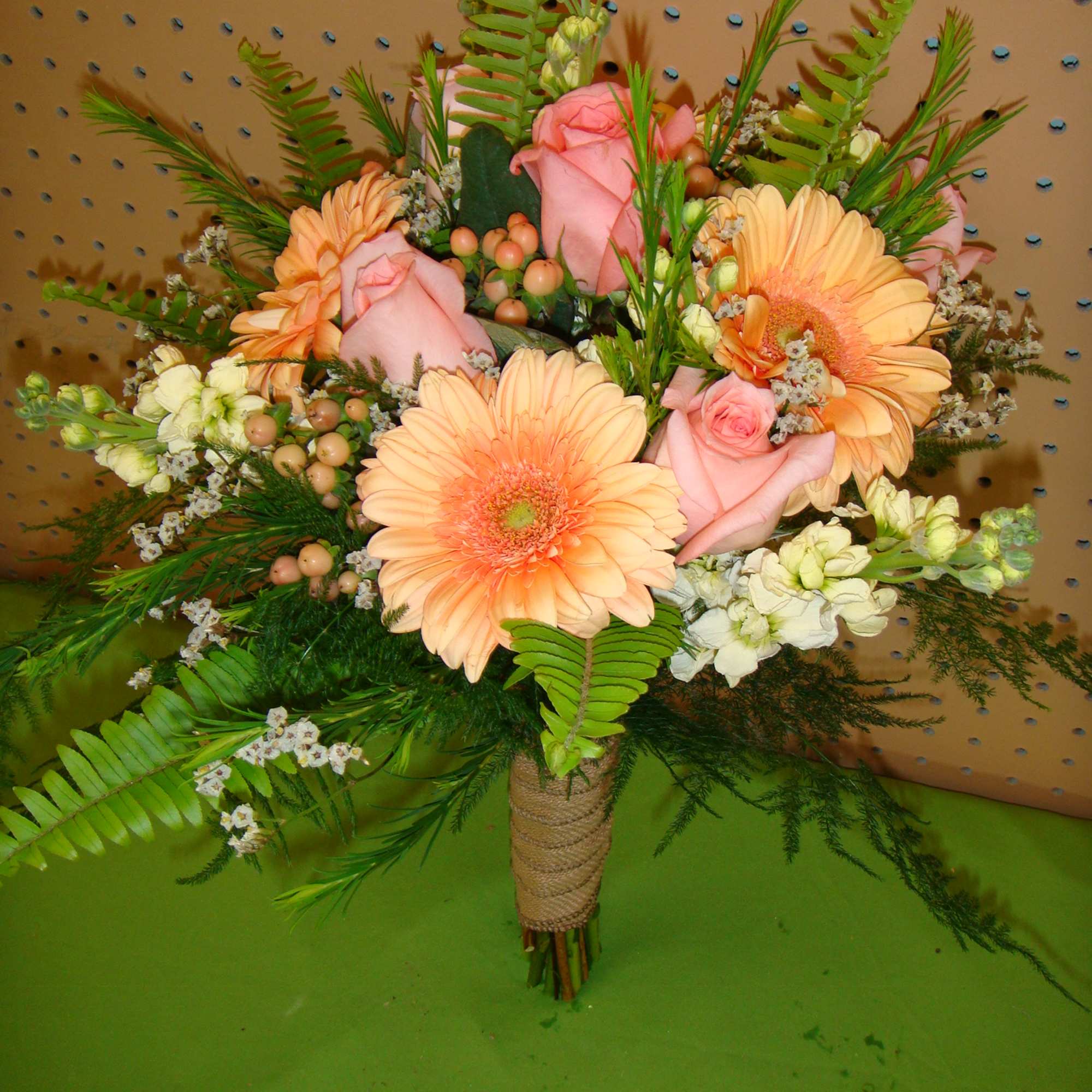Bouquet of peach gerbera daisies and pink roses with greenery