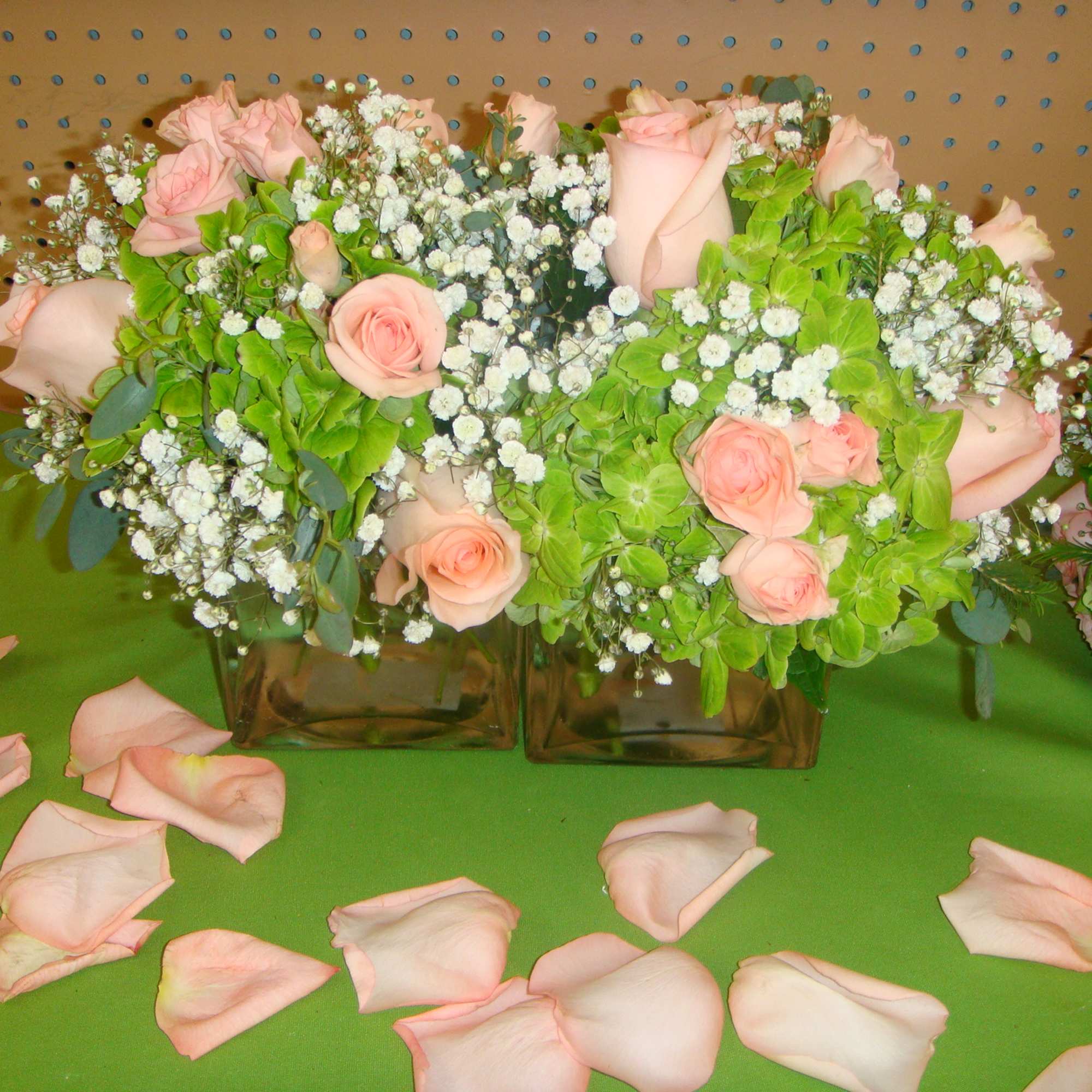 Pink roses and white baby's breath in square glass vases