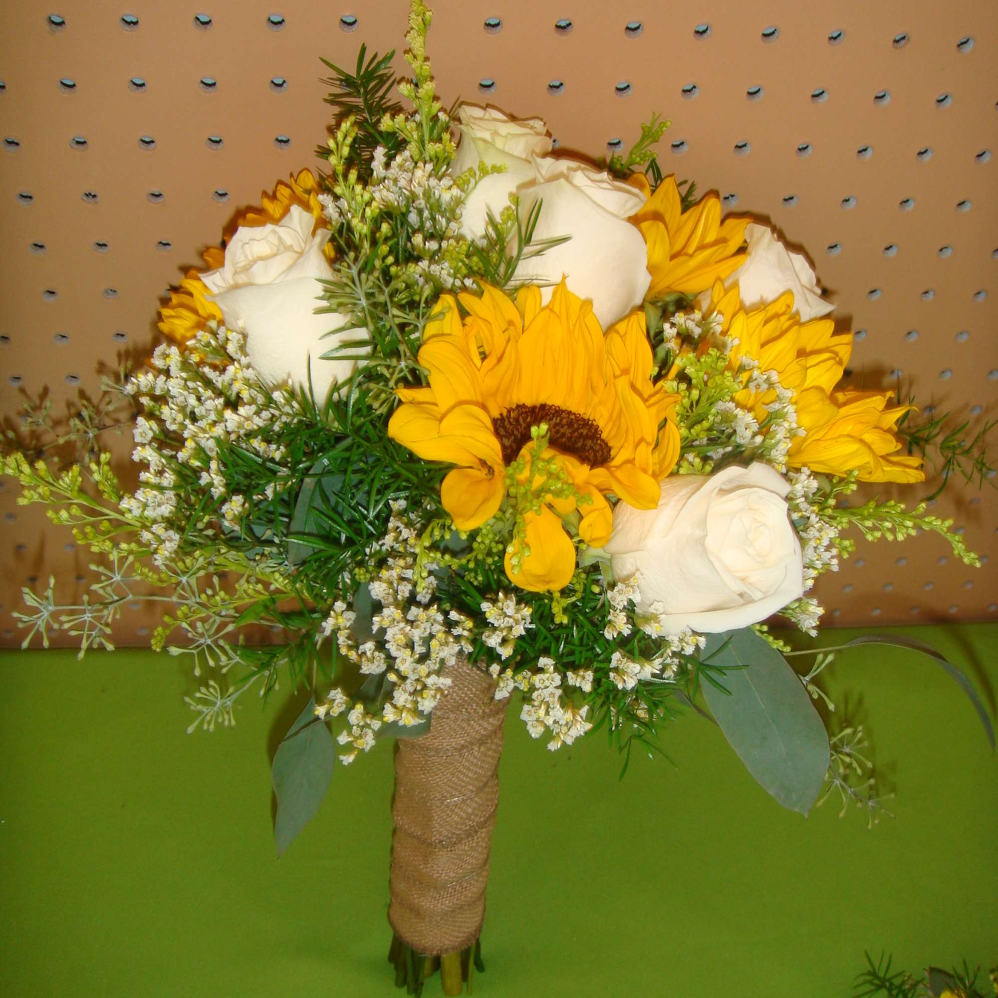 Bouquet of white roses and yellow sunflowers with small filler flowers