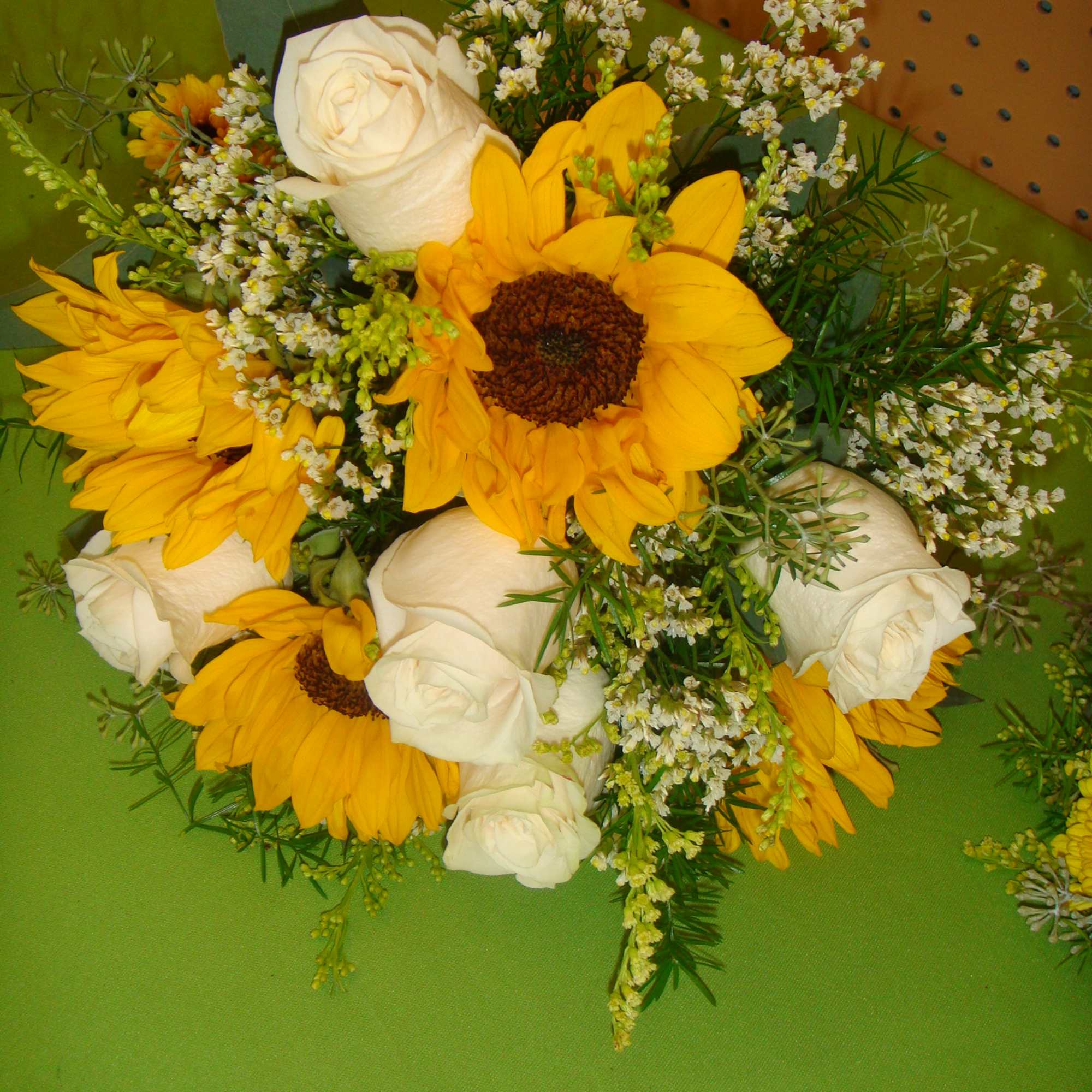 Bouquet of yellow sunflowers and white roses with small filler flowers