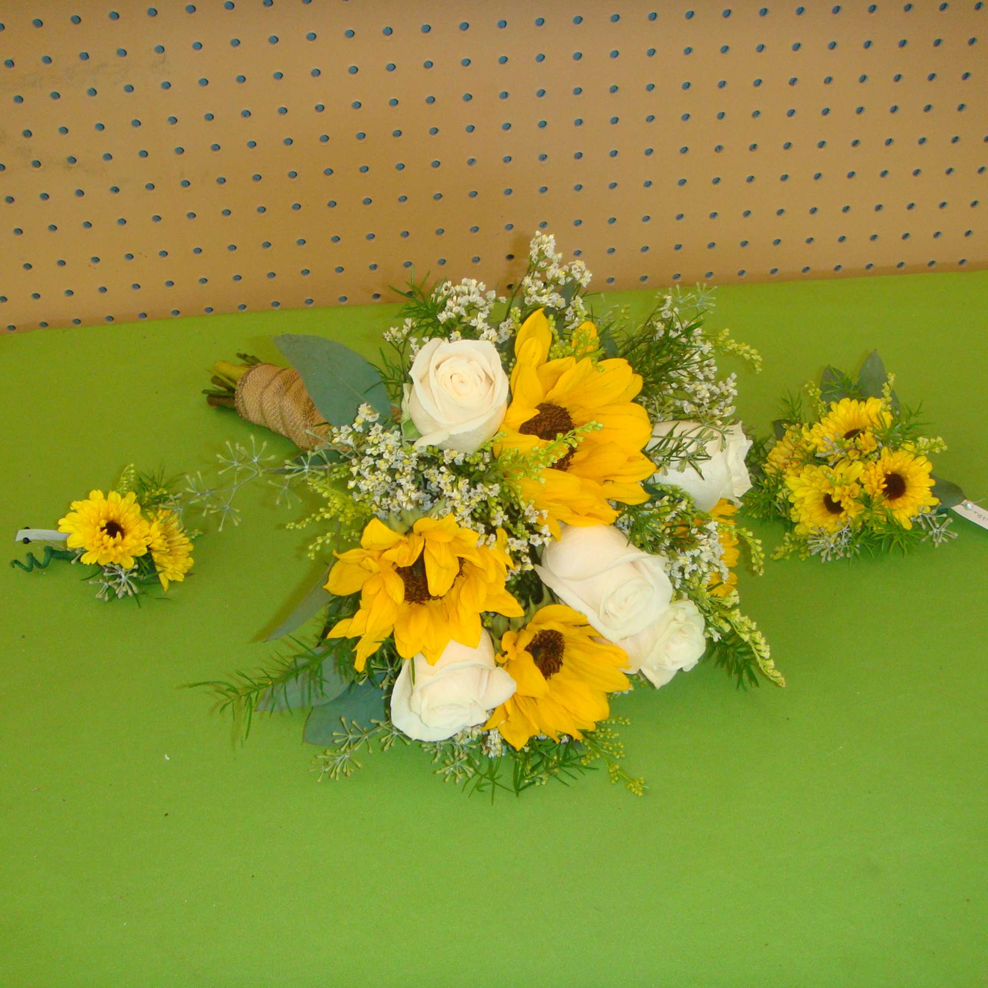Yellow sunflowers and white roses arranged with small filler flowers