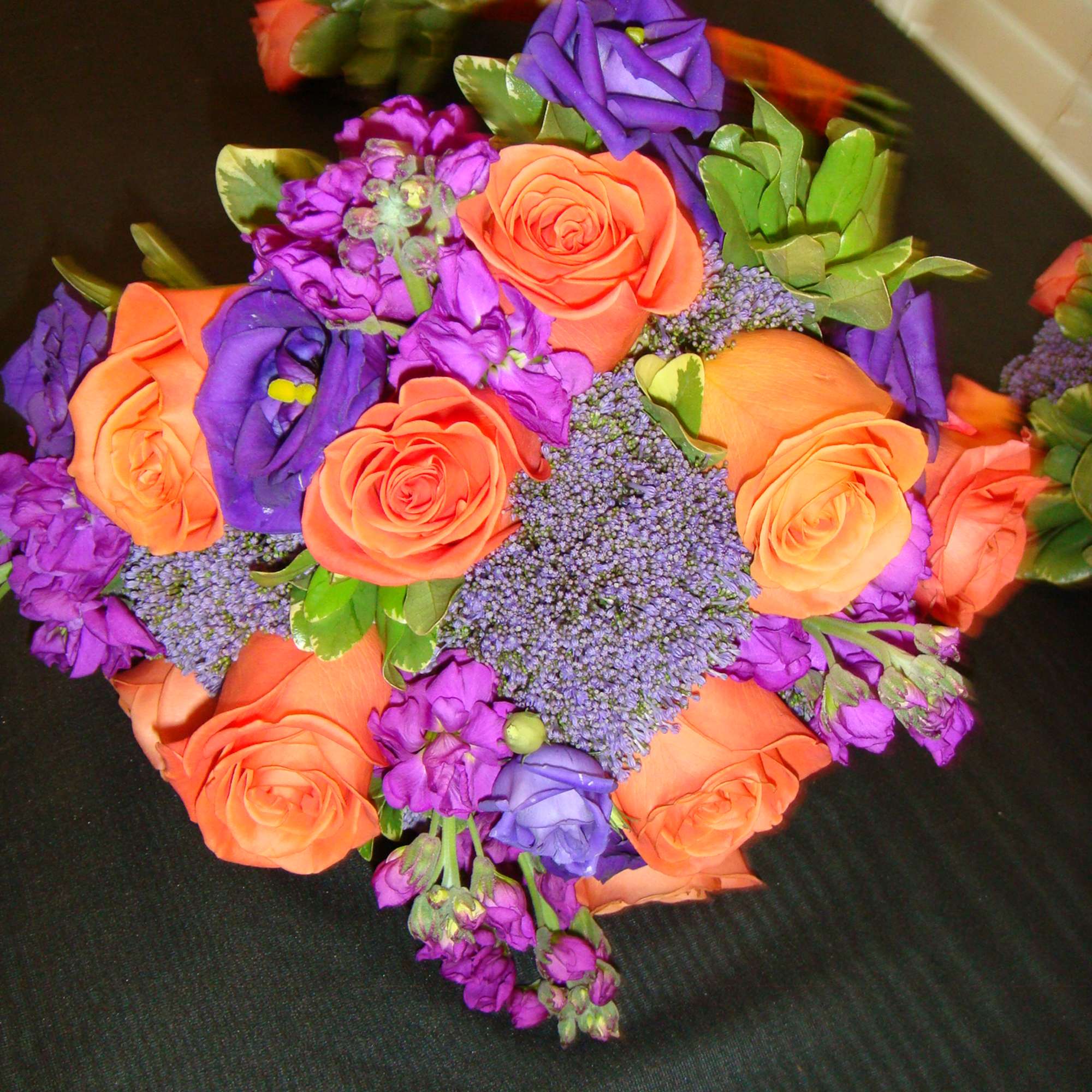 Bouquet of orange and purple roses with purple filler flowers