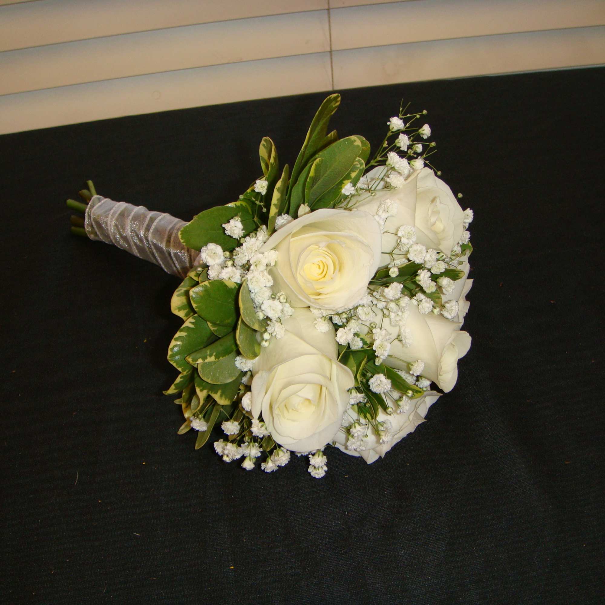 White rose bouquet with baby's breath and green leaves