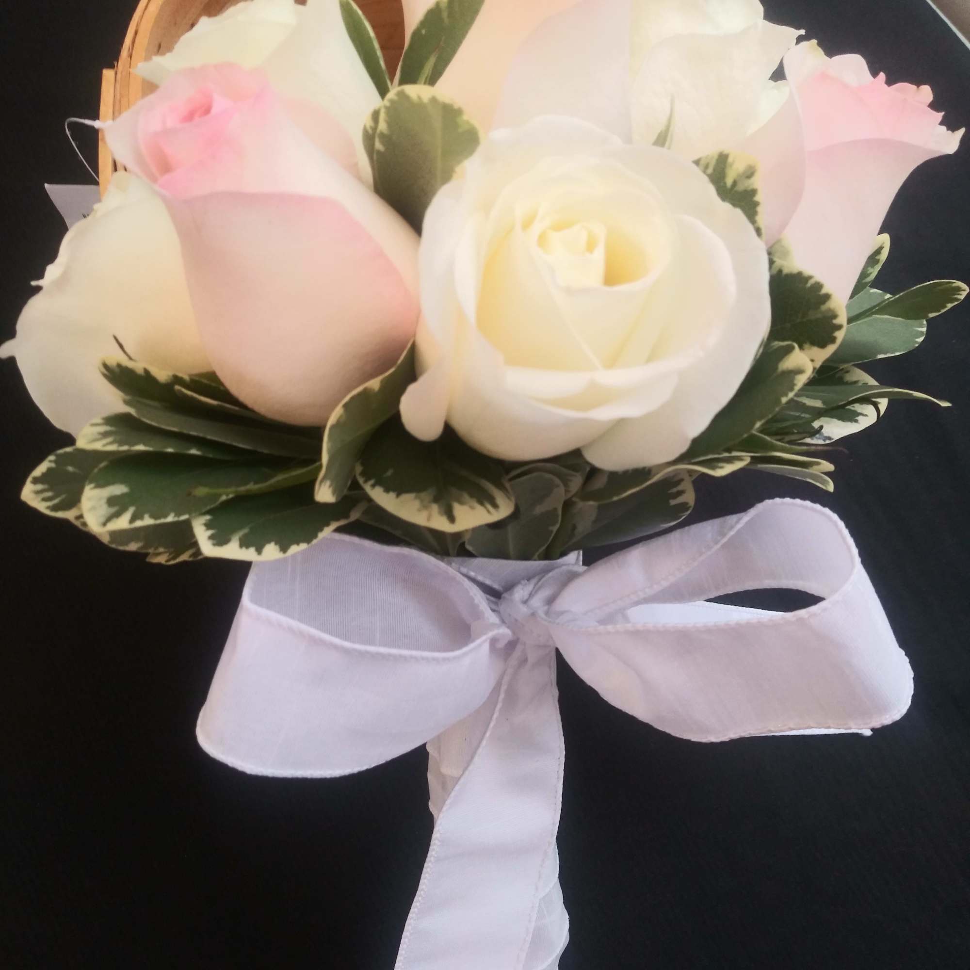 Bouquet of pale pink and white roses with a white ribbon